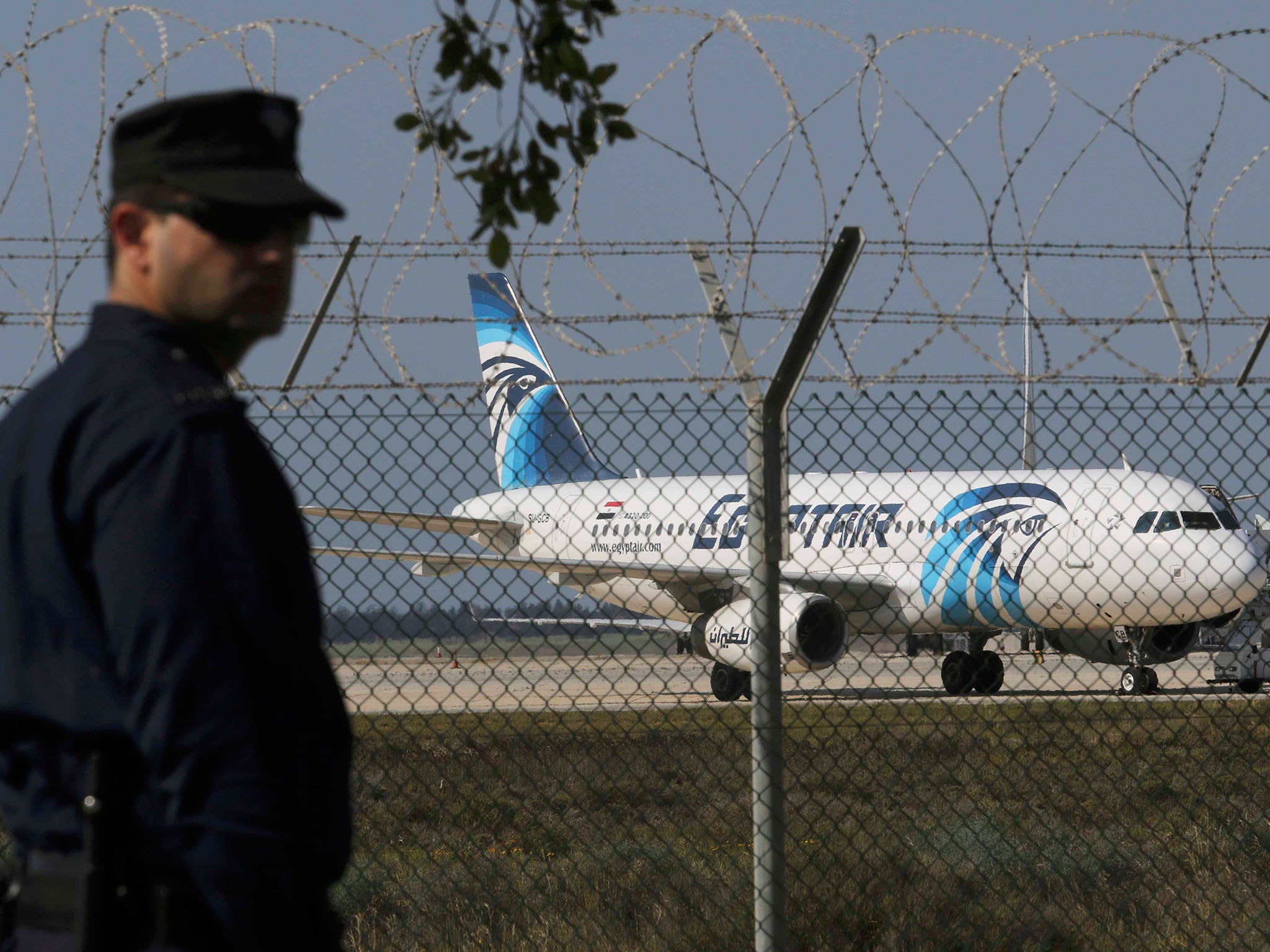 A policeman stands guard at Larnaca Airport near a hijacked Egypt Air A320