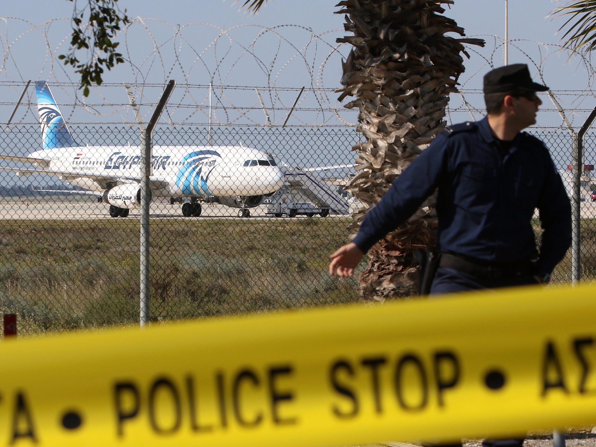 A Cypriot policeman stands guard near a hijacked EgyptAir A320 plane at Larnaca Airport, Cyprus (EPA)