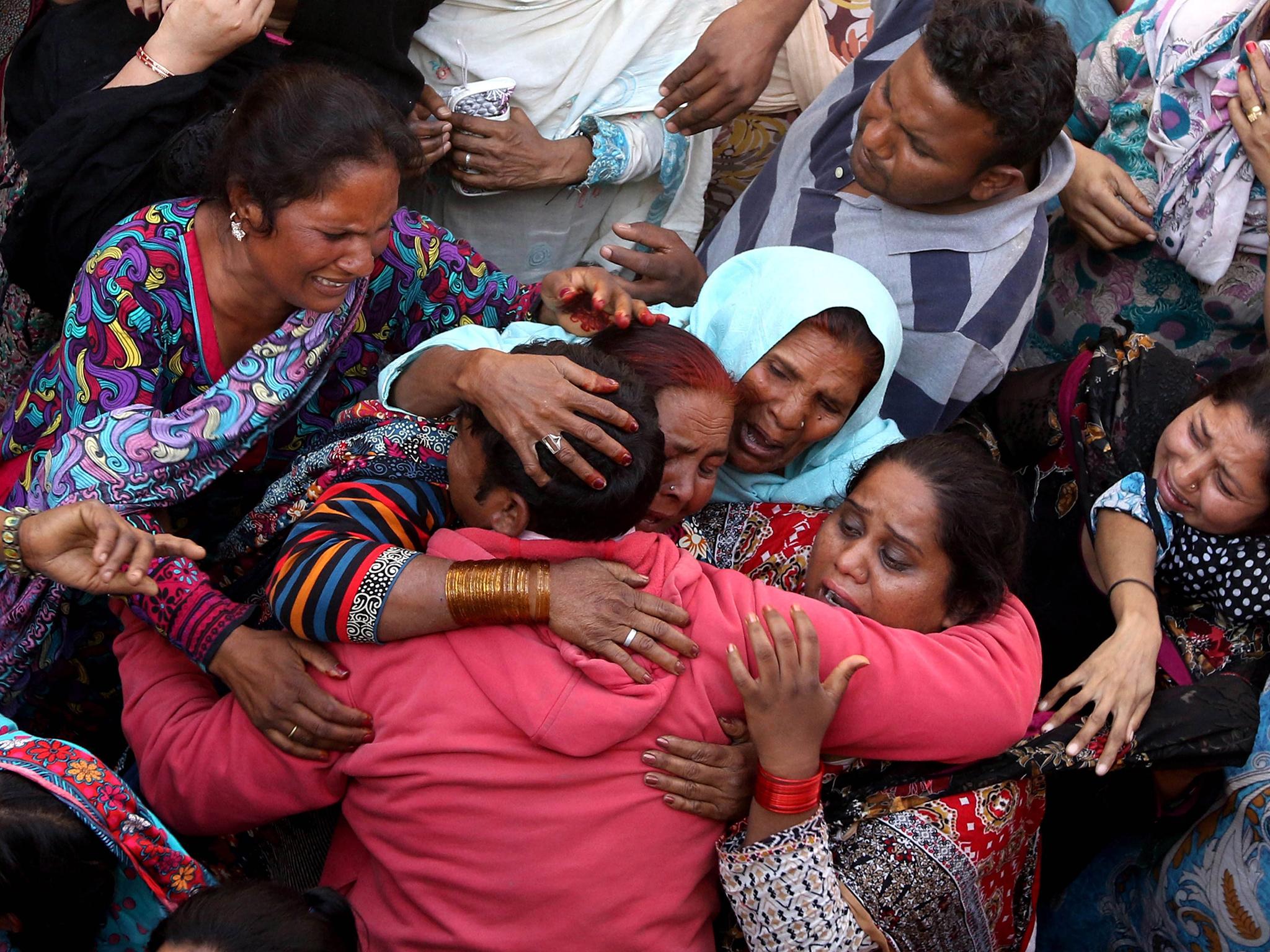 People cry during the funeral of their loved ones a day after a suicide bomb attack at a park, in Lahore, Pakistan, in 2016