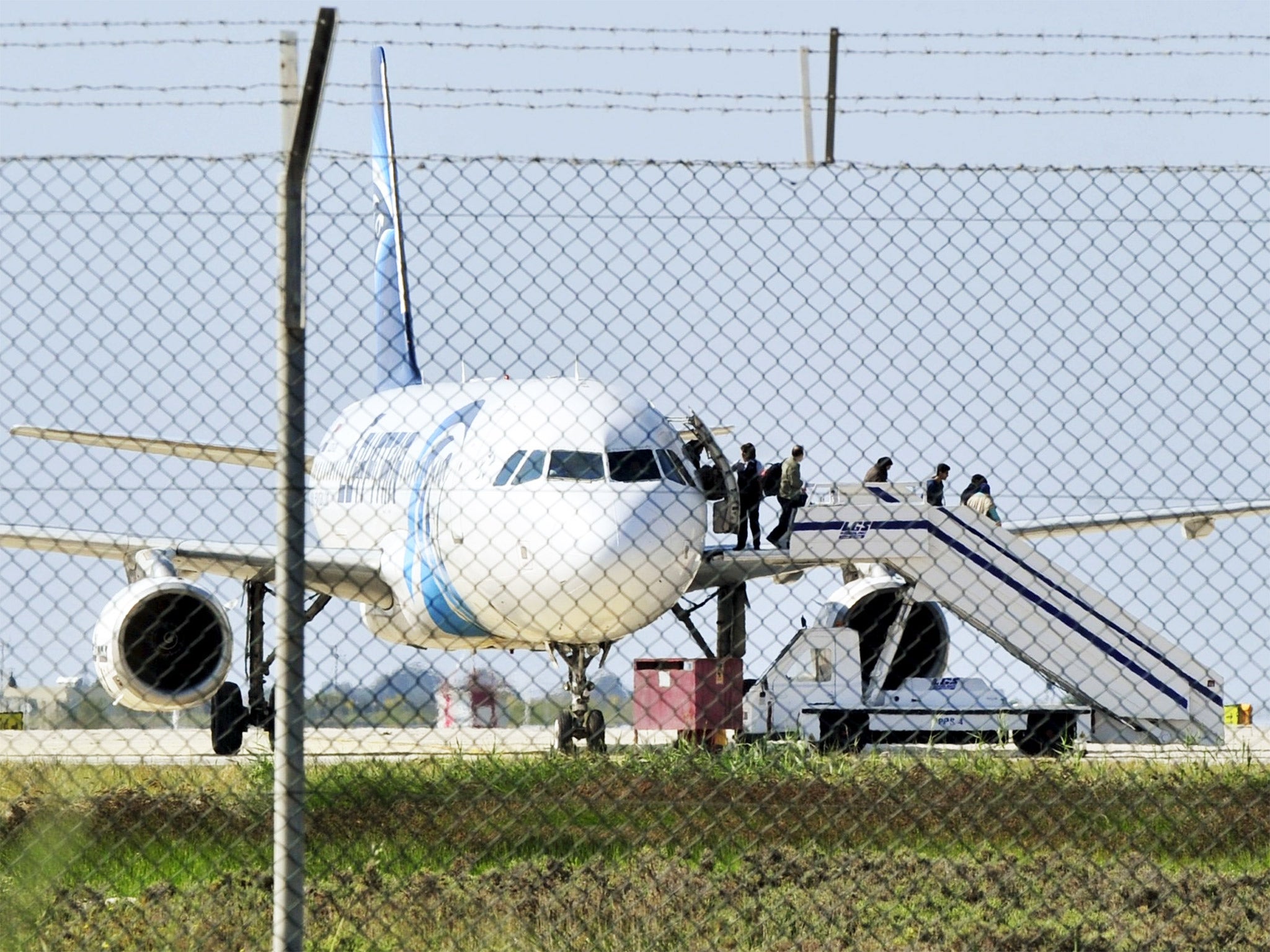 Passengers evacuate a hijacked EgyptAir plane at Larnaca airport on Tuesday