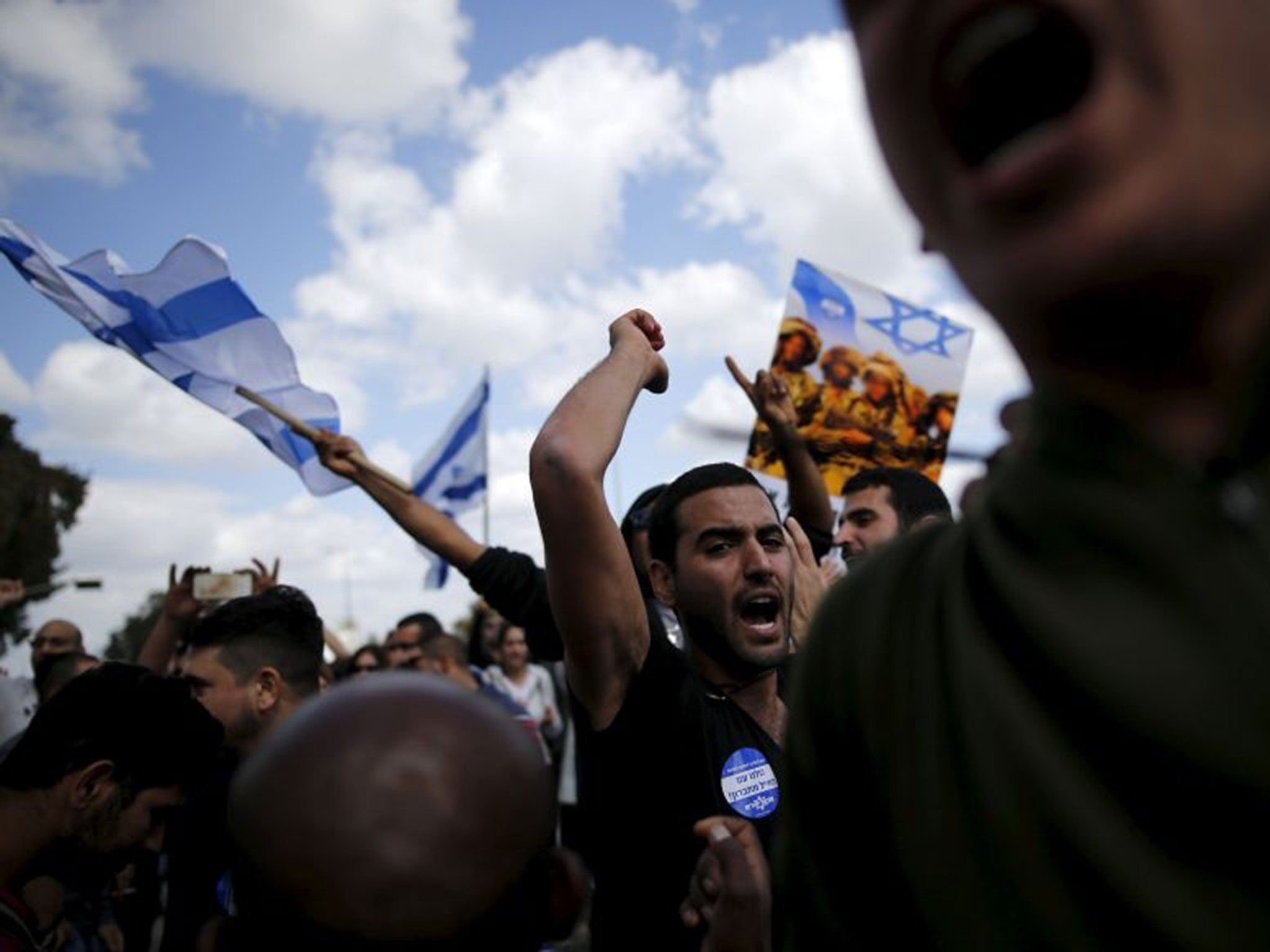 Israeli right-wing protesters demonstrate outside a military court during a hearing of an Israeli soldier who the military said has been arrested on suspicion of murder, near the southern Israeli city of Kiryat Malachi, 29 March, 2016