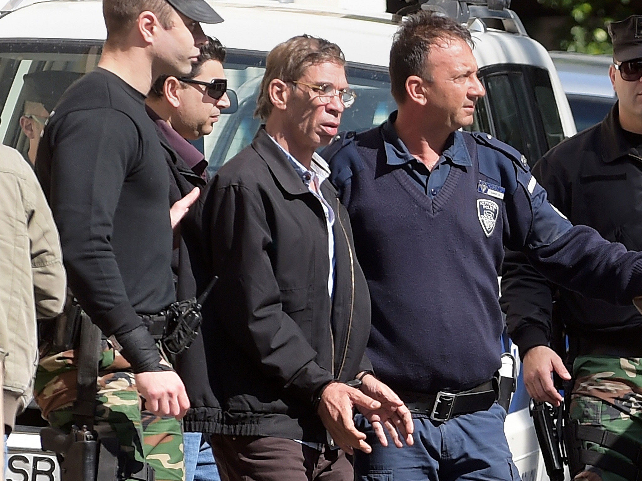 Mustafa wears handcuffs as he leaves the court in Larnaca escorted by Cypriot police (AFP) (AFP)