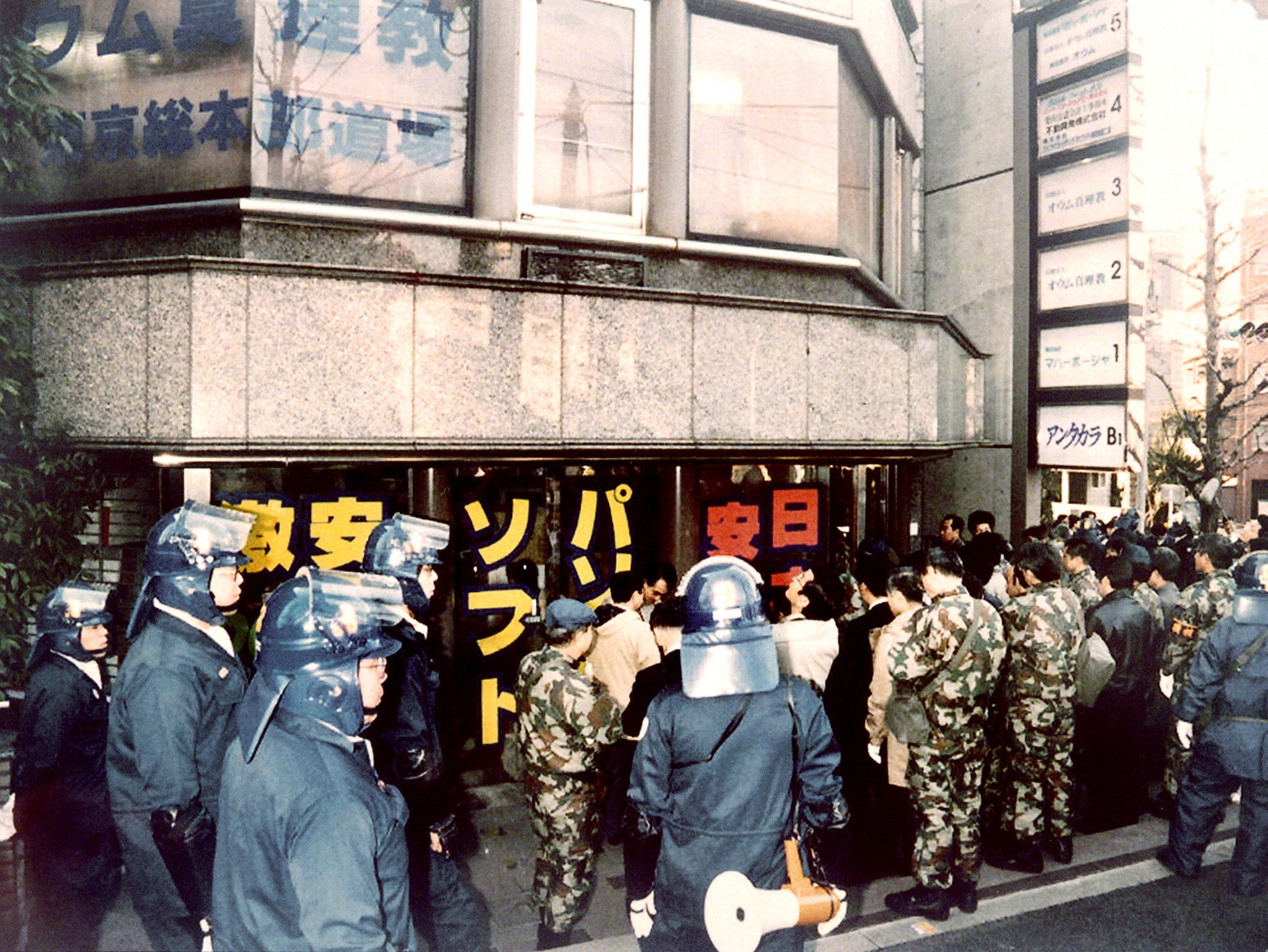 Riot policemen surround the Tokyo headquarters of the controversial Aum sect, on March 22, 1995.
