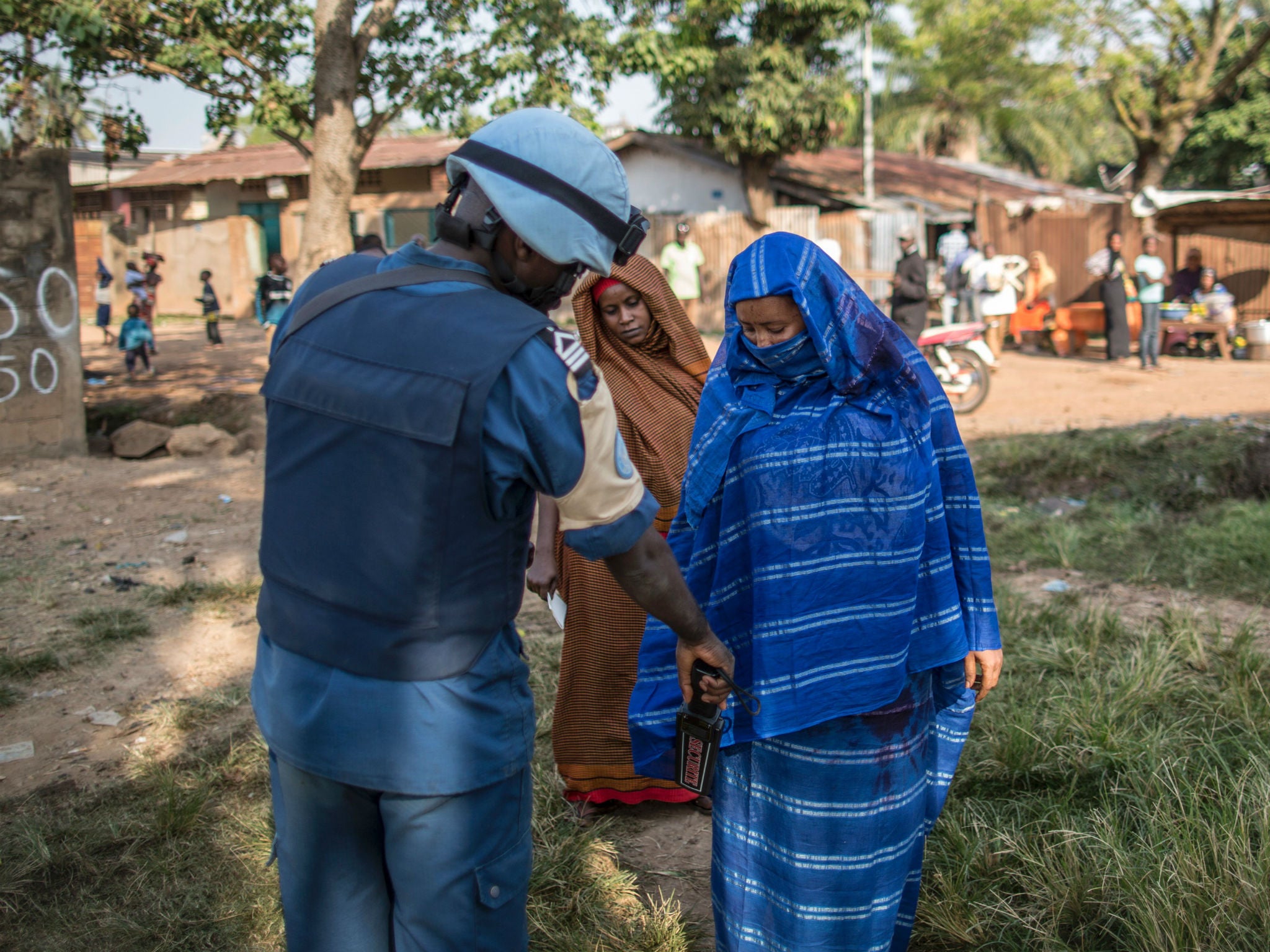 A Burundian soldier of the UN peacekeeping force MINUSCA contingent uses a metal detector at the entrance of a polling station in Bangui on December 14, 2015