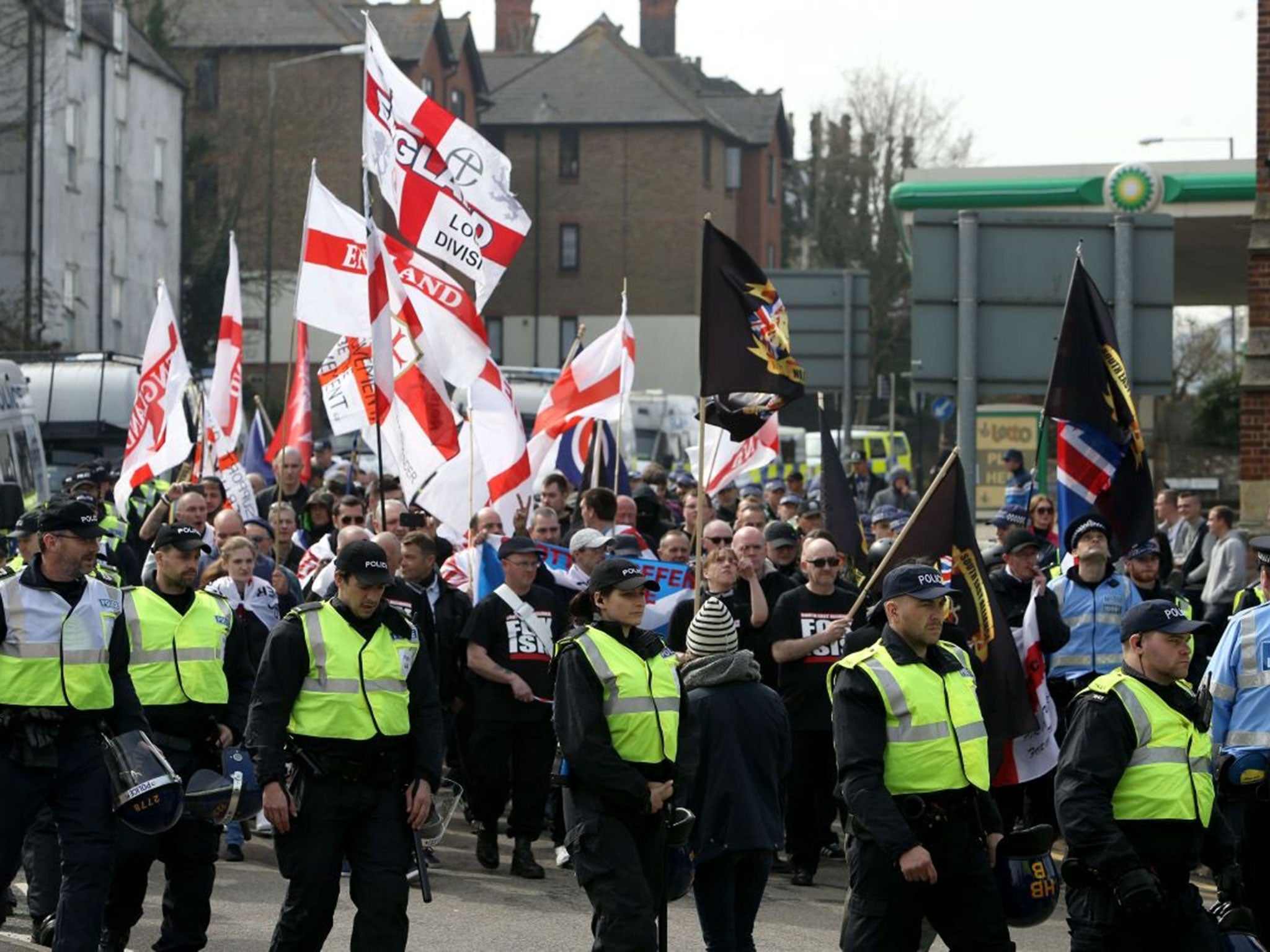 Police officers march with a group of far-right protesters in Dover, Kent, who are protesting against the arrival of immigrants