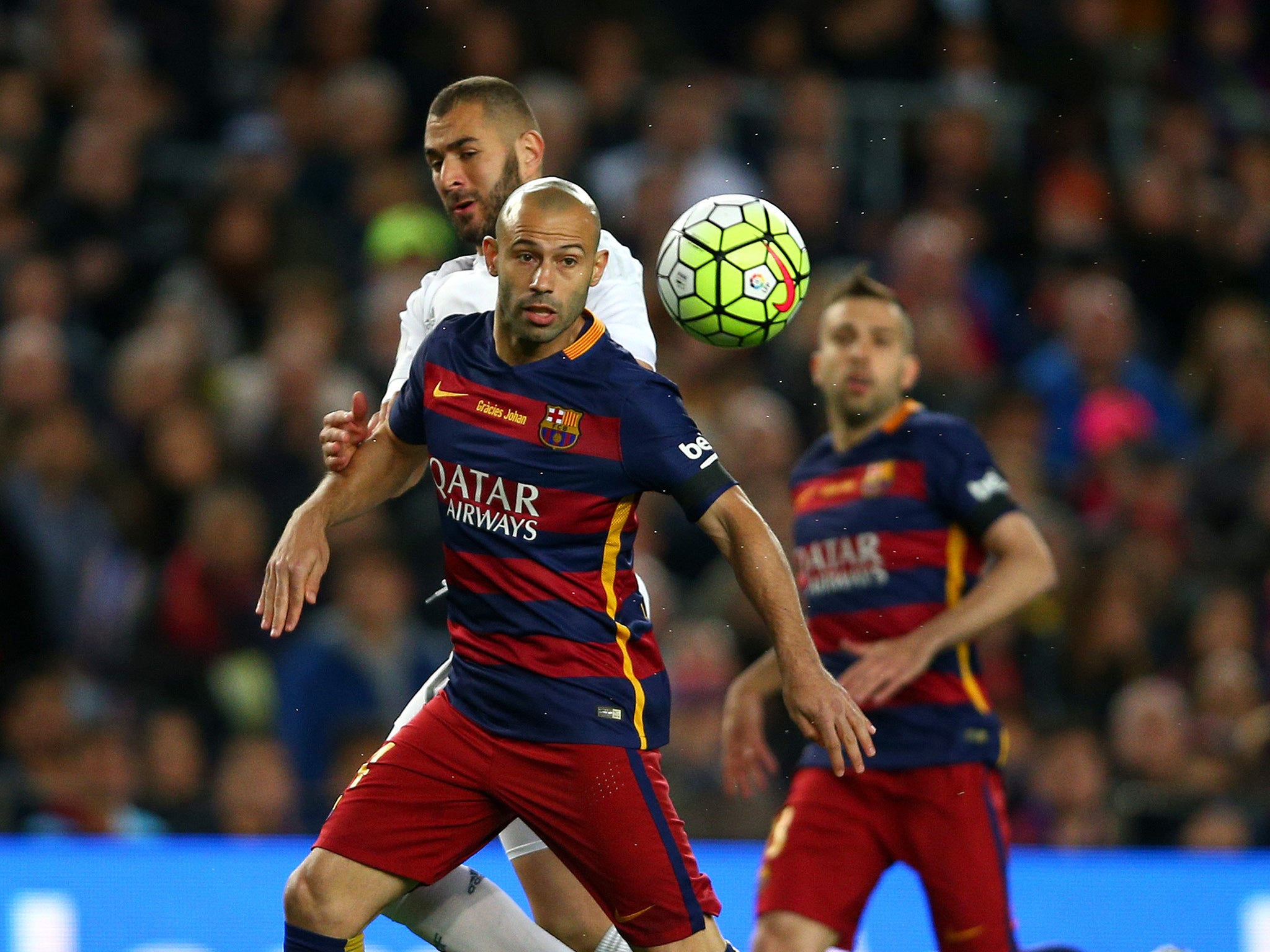 Javier Mascherano holds off Karim Benzema