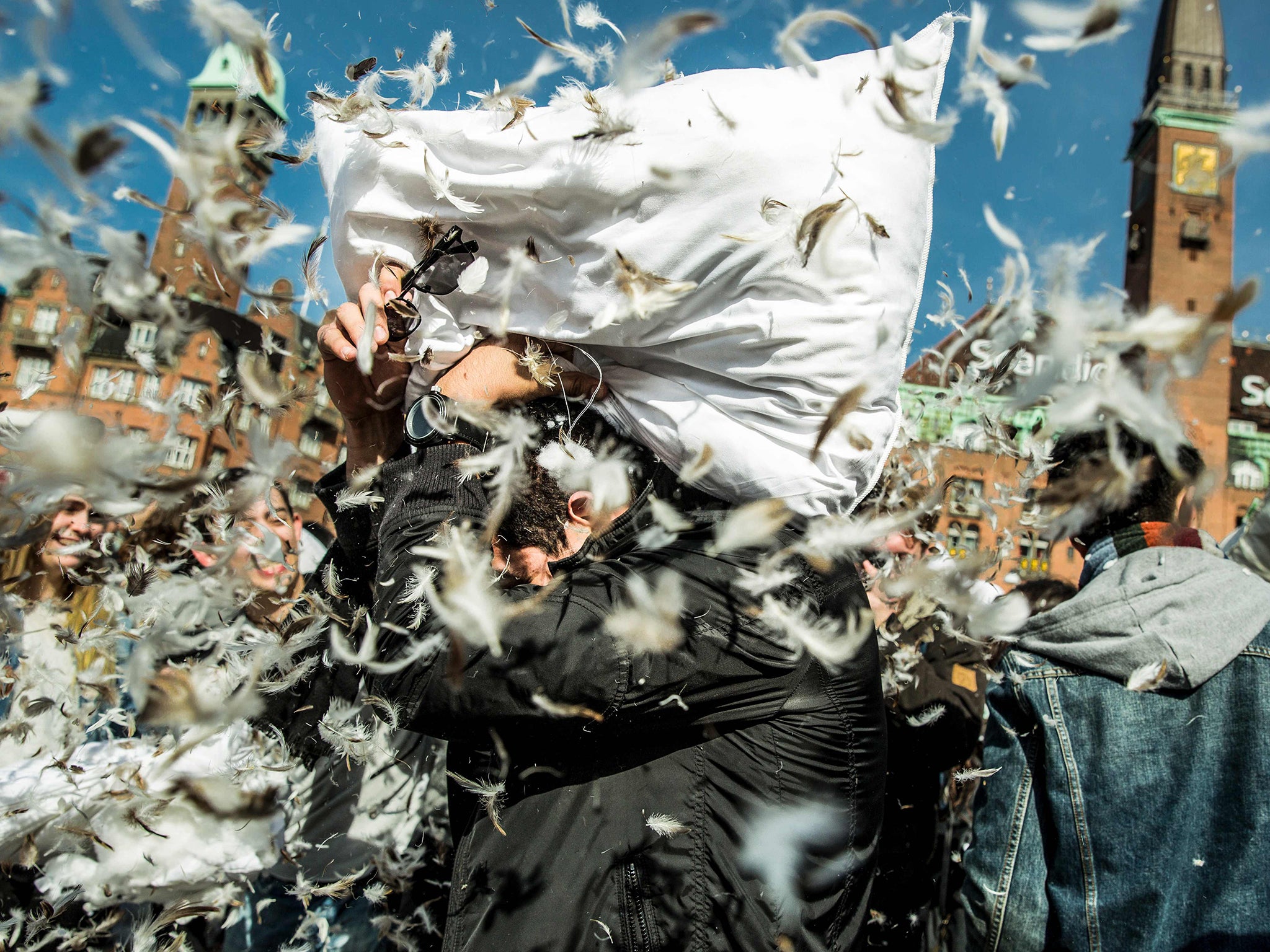 People fight with pillows during World Pillow Fight Day in front of the City Hall in Copenhagen, Denmark