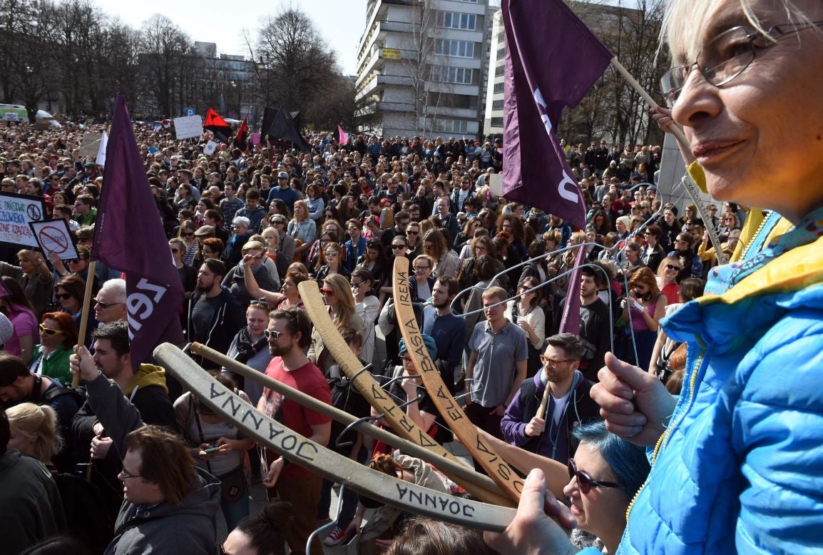 A demonstrator holds hangers, symbolizing illegal abortion, as she protests with other demonstrators against a possible tightening of the Poland's abortion law.