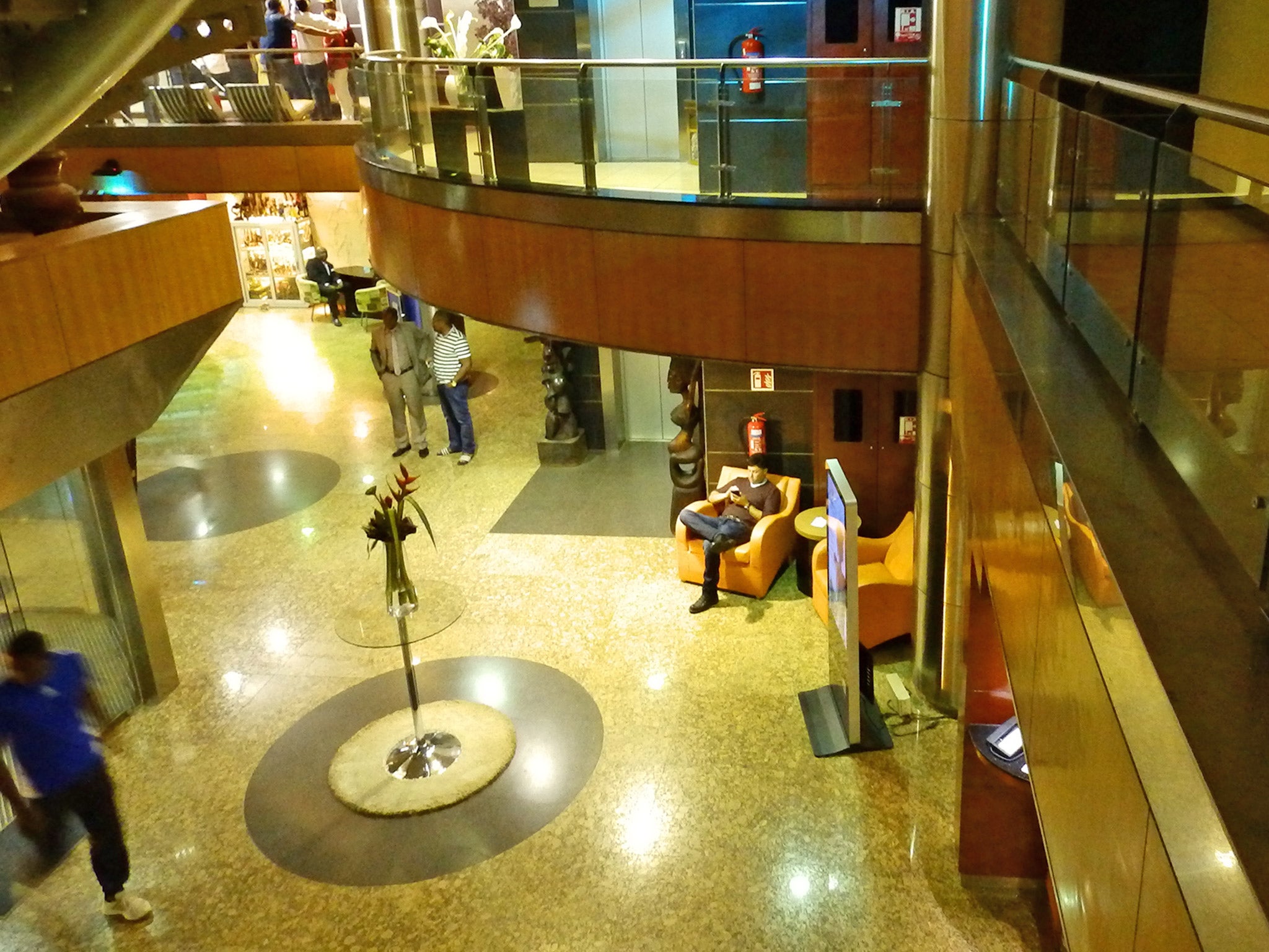 Top: the scene shortly after the attack at the Radisson Blu. Bottom: the hotel lobby today (Getty; Lizzie Dearden)