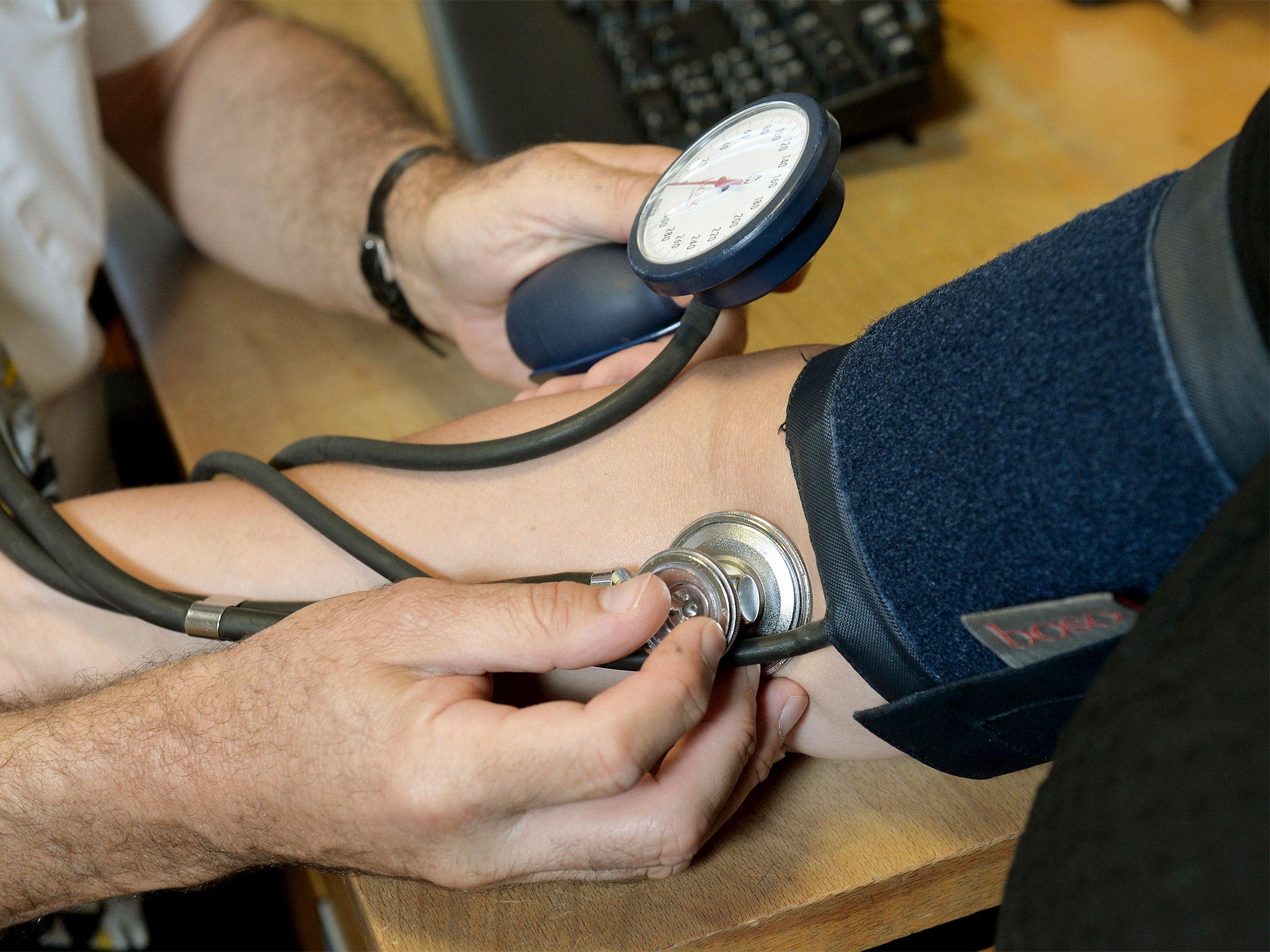 A GP checking a patient's blood pressure