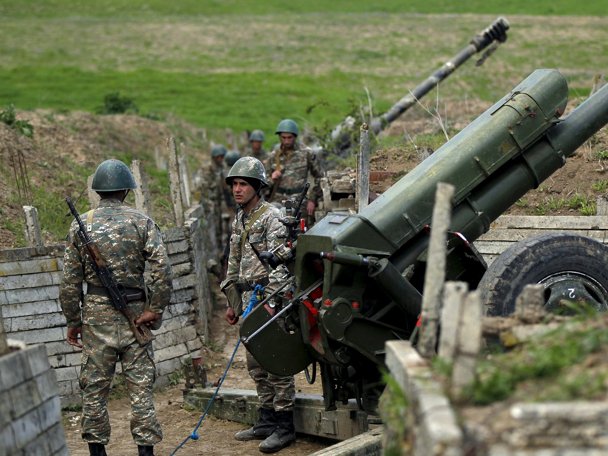 Ethnic Armenian soldiers stand next to a cannon at artillery positions near the Nagorno-Karabakh's town of Martuni