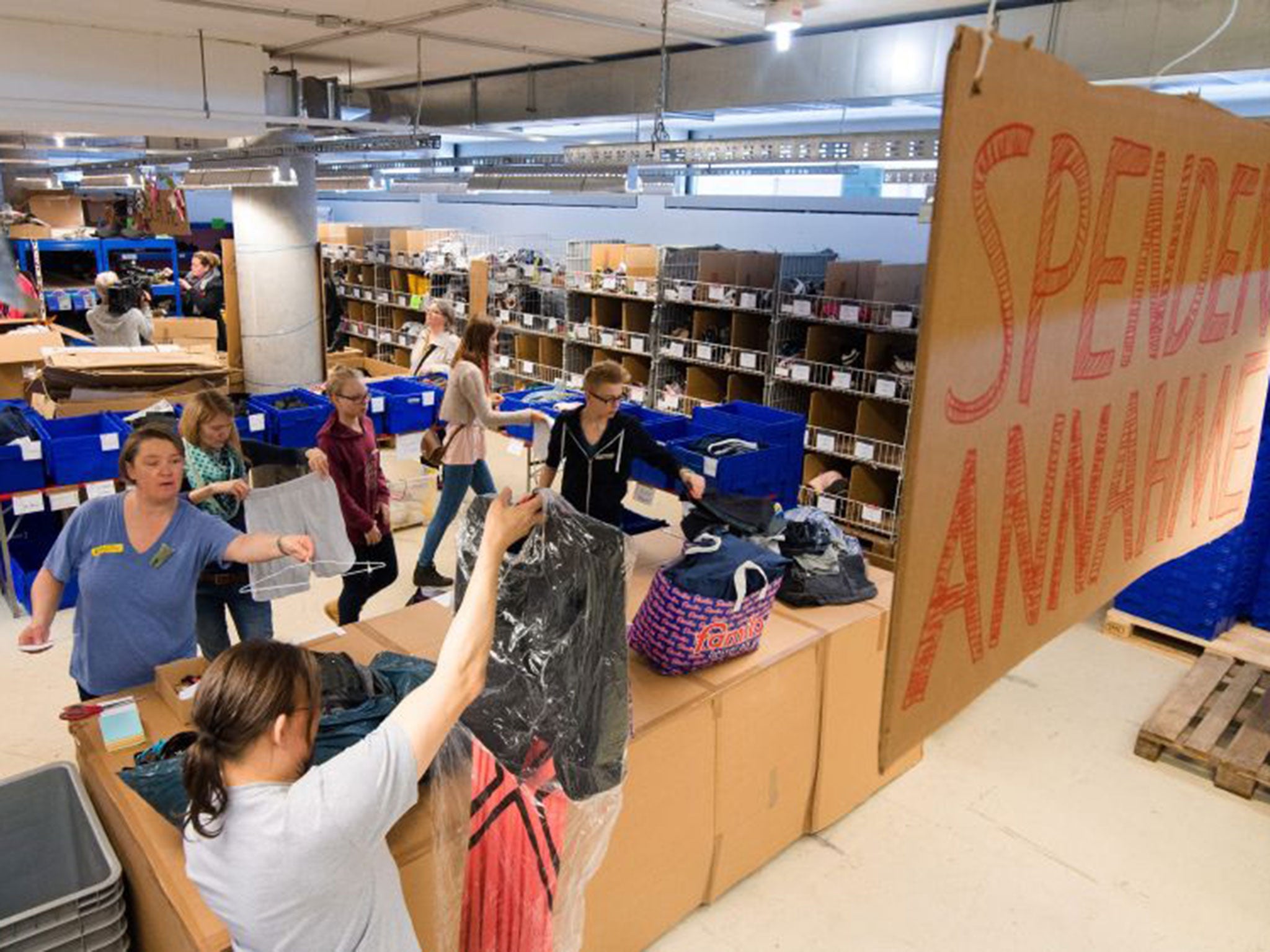 Helpers organising and repairing clothes donated for refugees at a centre in Hamburg, Germany