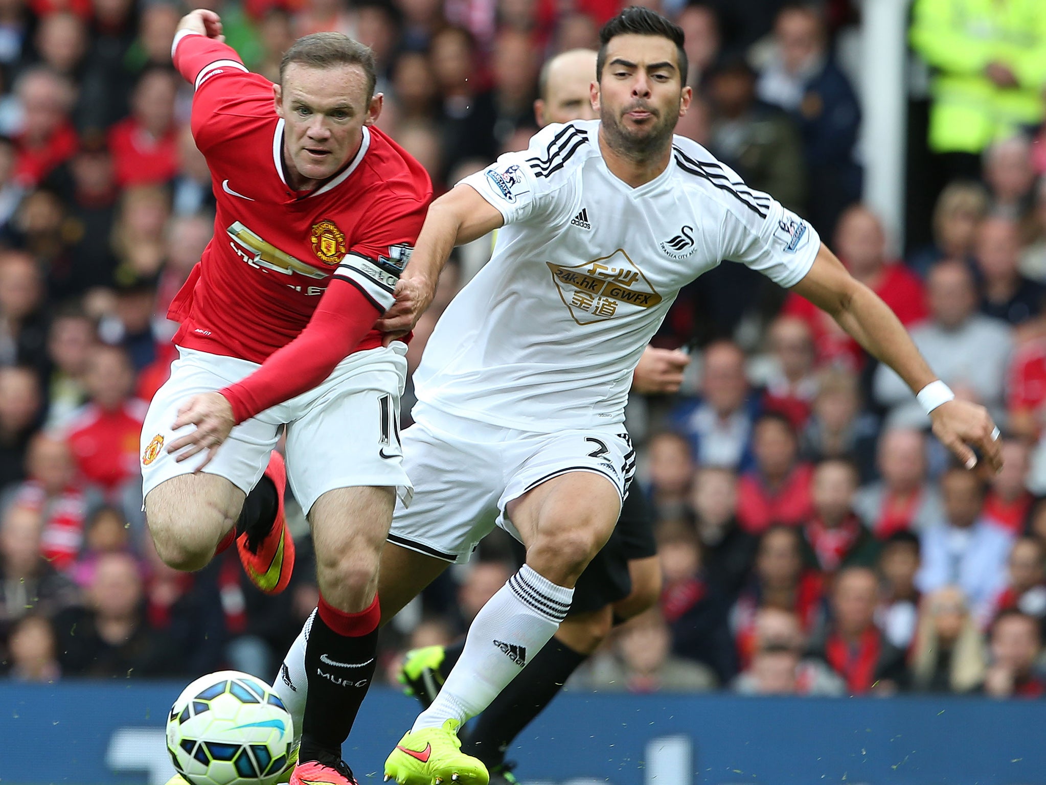 Jordi Amat challenges Wayne Rooney for the ball