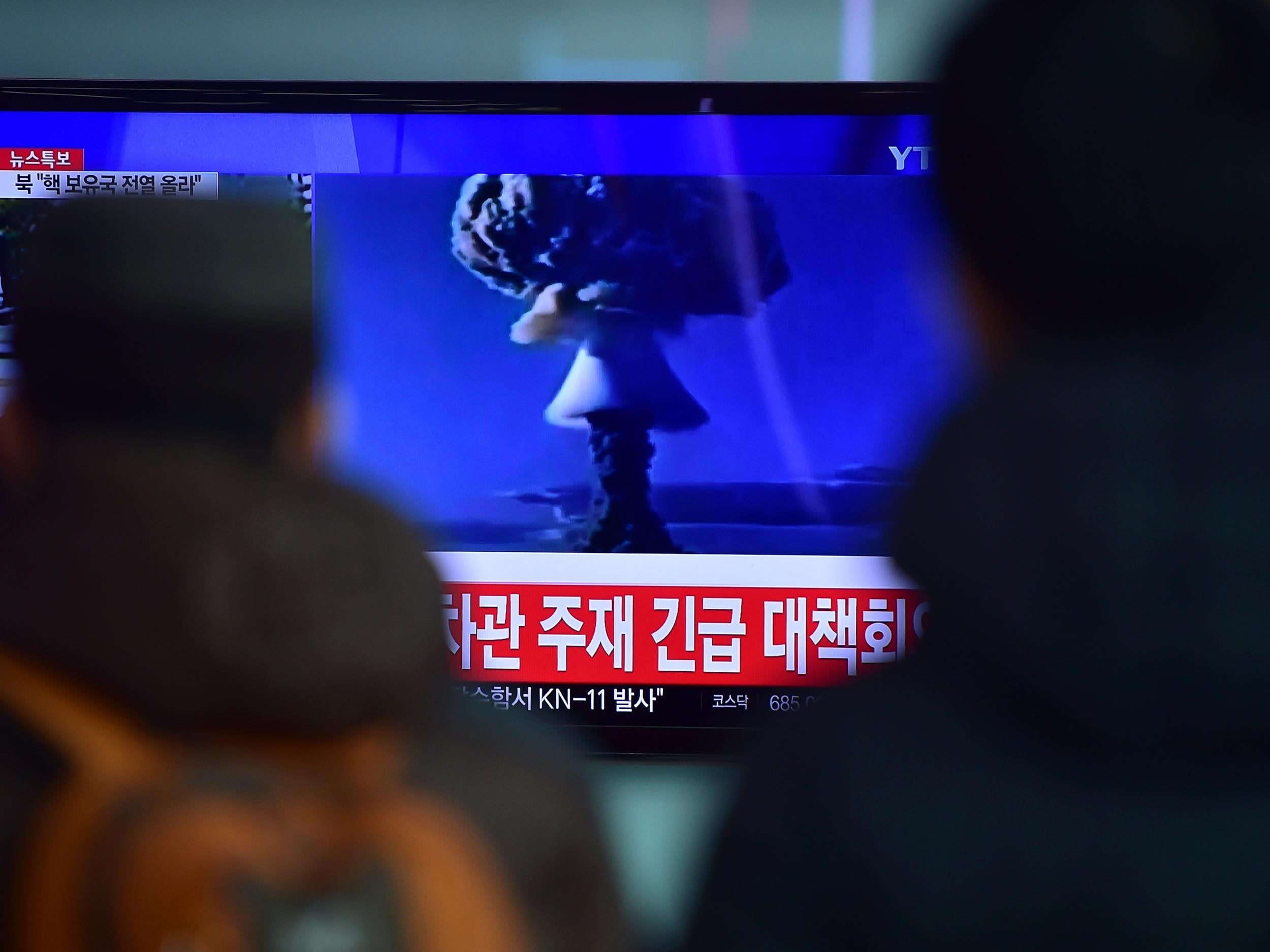 People watch a news report on North Korea's first hydrogen bomb test at a railroad station in Seoul on January 6, 2016