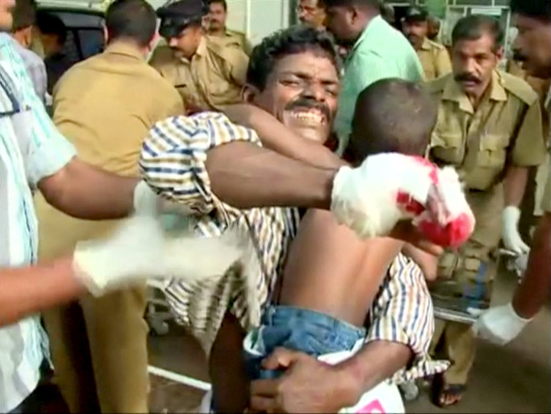 An injured father carries his son to hospital for medical attention