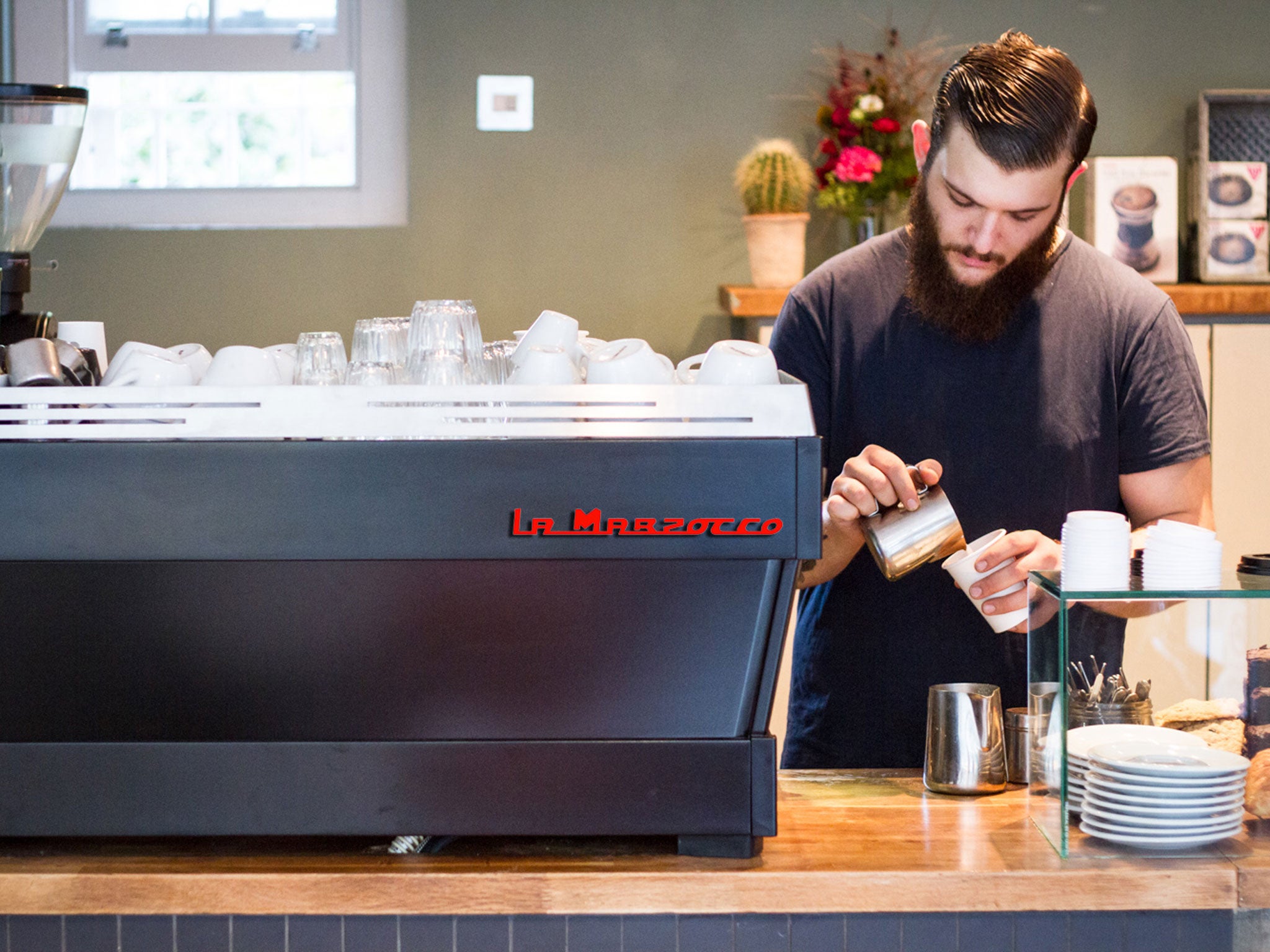 A barista prepares a coffee at Climspon and Sons