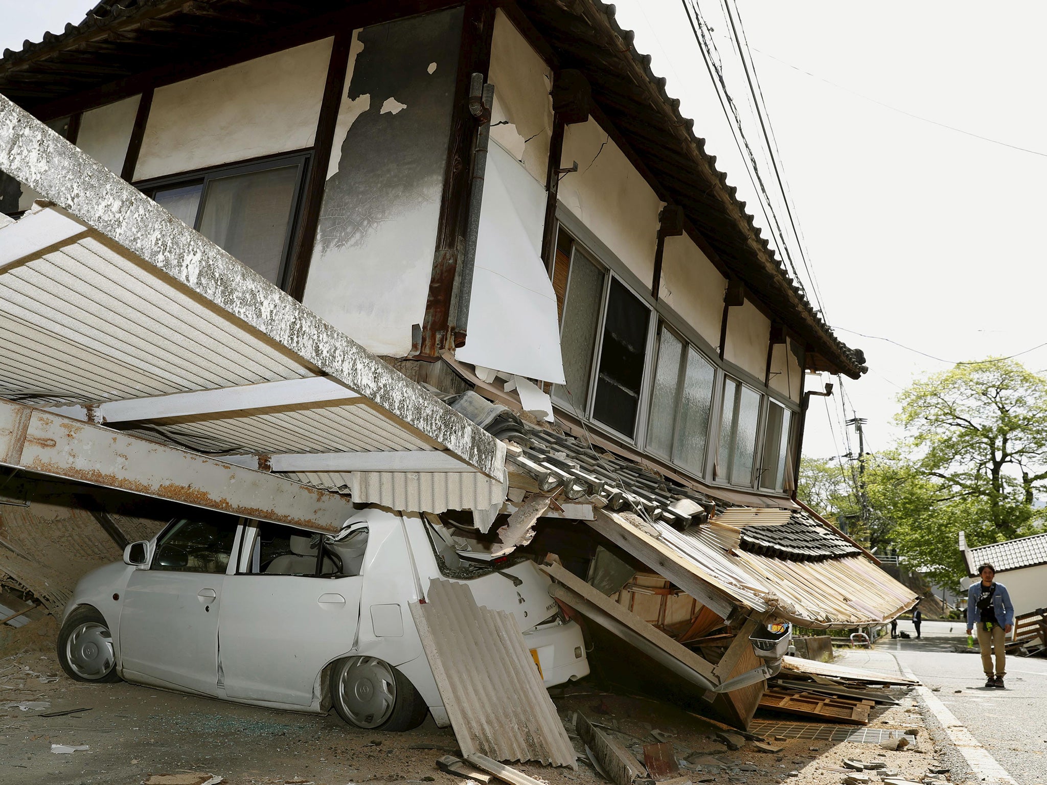 An earthquake-damaged house and car caused in Mashiki