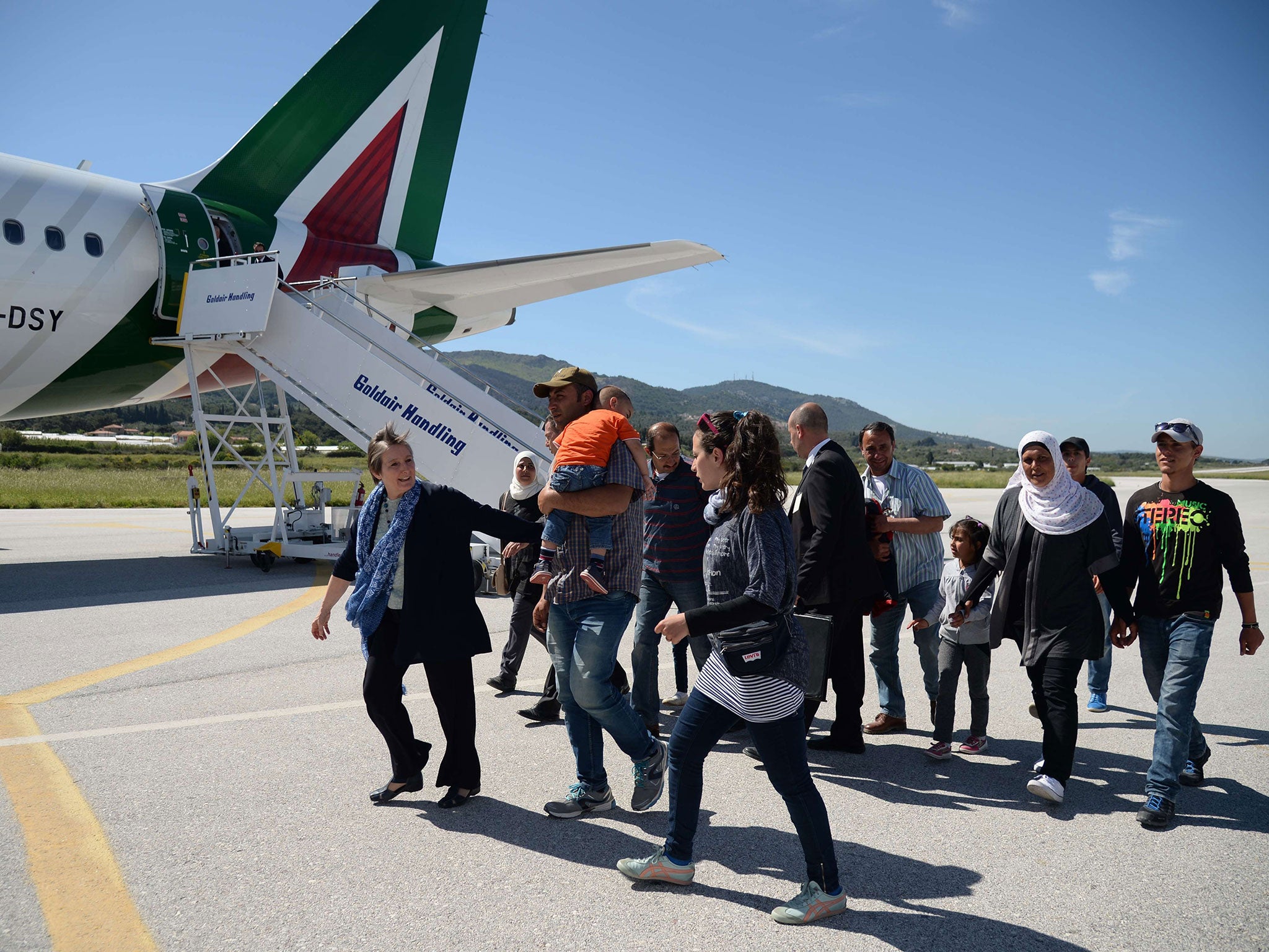 A group of Syrian refugees arrive to board a plane with Pope Francis on April 16, 2016 in Lesbos