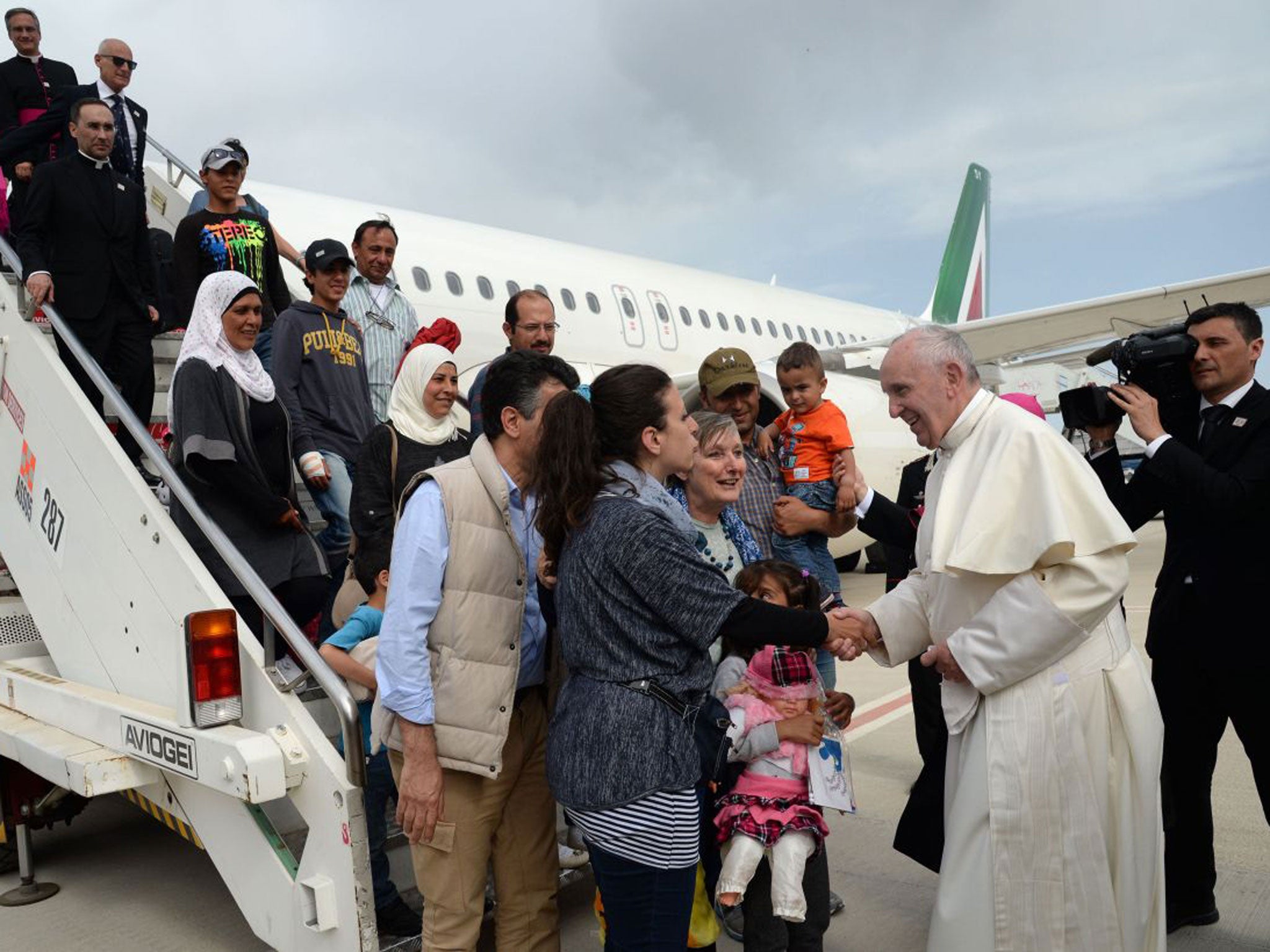 The Pope greets three refugee families who he invited to the Vatican
