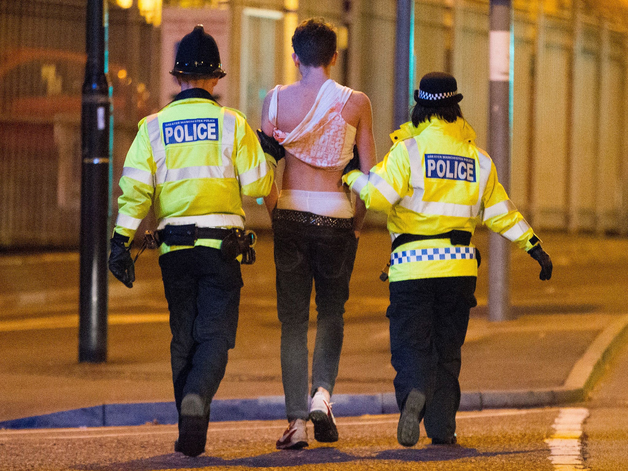 A drunk student is led away by police officers in Manchester