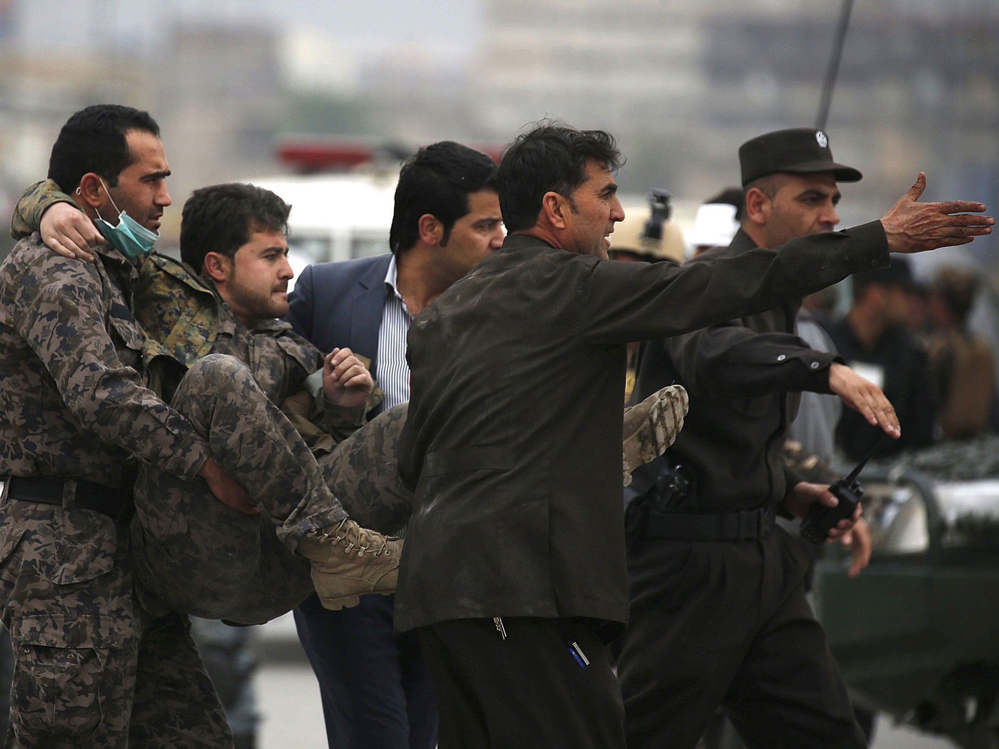 Afghan security forces carry an injured security personnel after a suicide car bomb attack in Kabul, Afghanistan April 19, 2016.