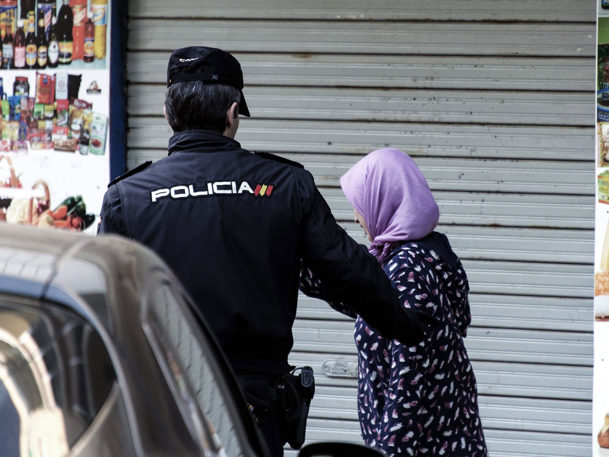 A policeman with a resident in the district in Palma de Mallorca, Spain, 19 April 2016, where a man was detained