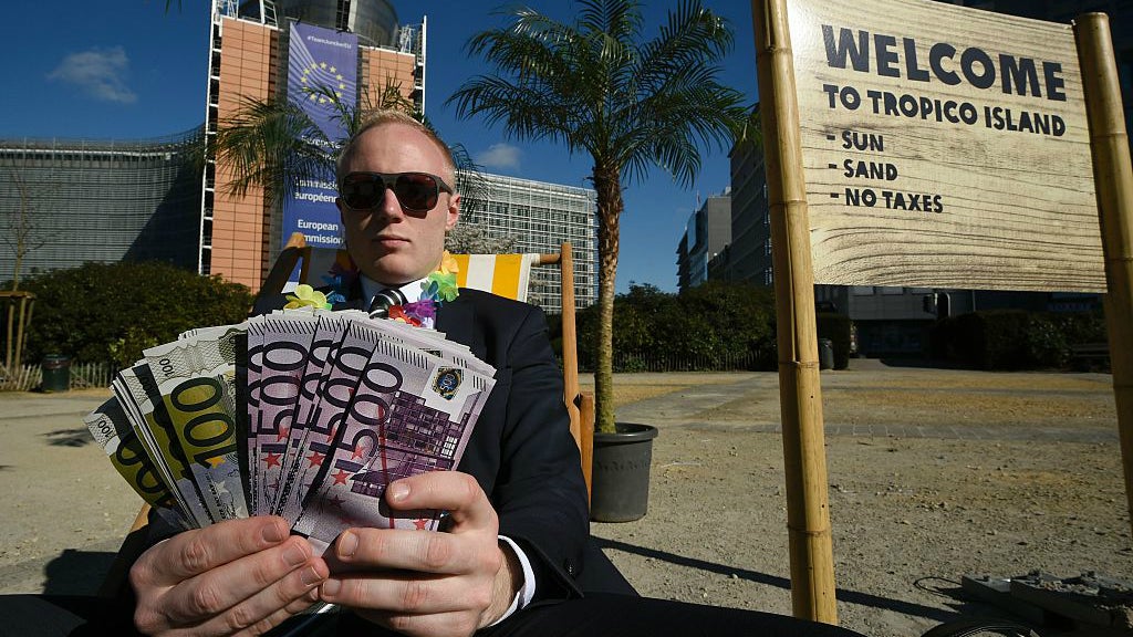 An activist performs as a client of an offshore company during a protest in front of the European Commission headquarters in Brussels, on April 12, 2016