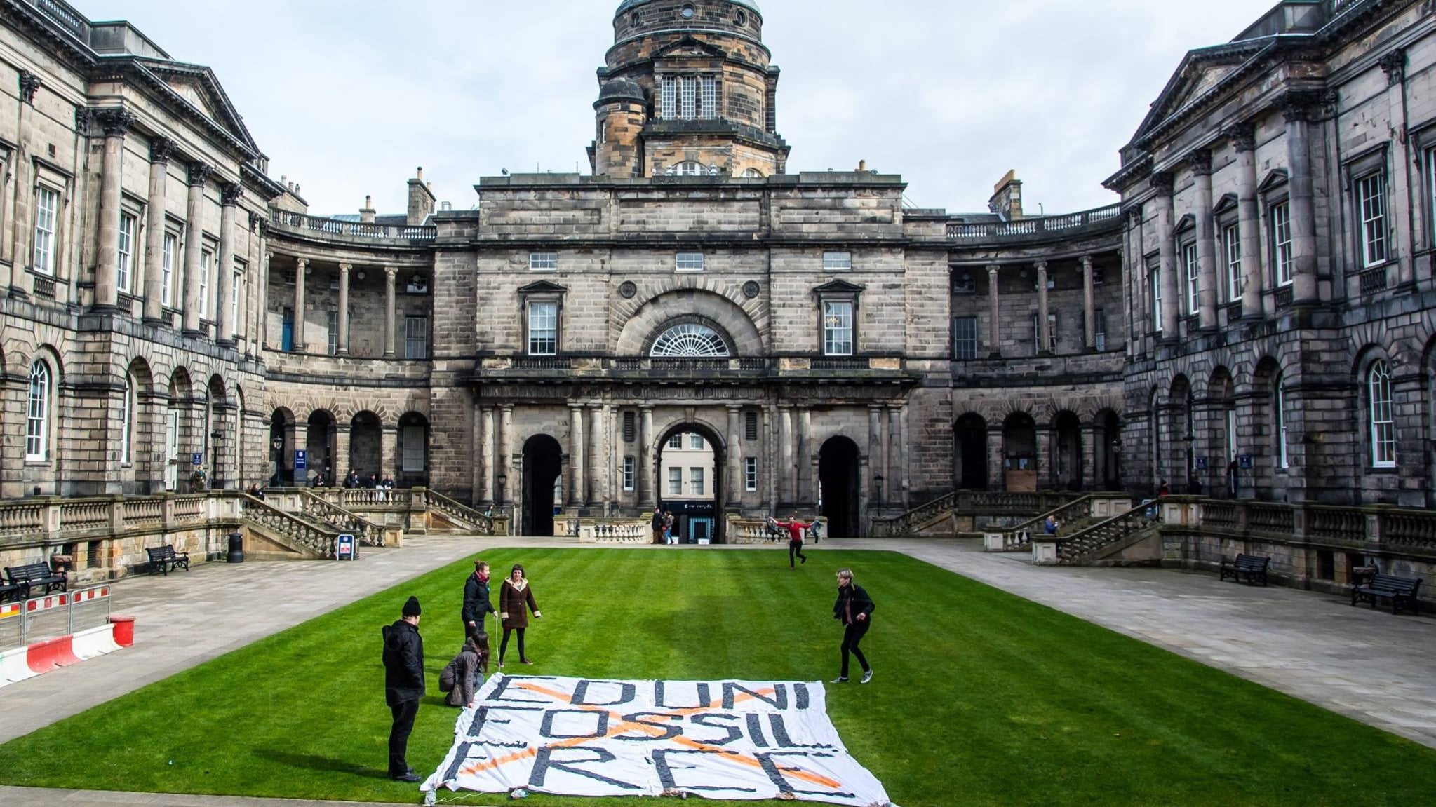 Some of the protesters lay out a banner at the university earlier this month