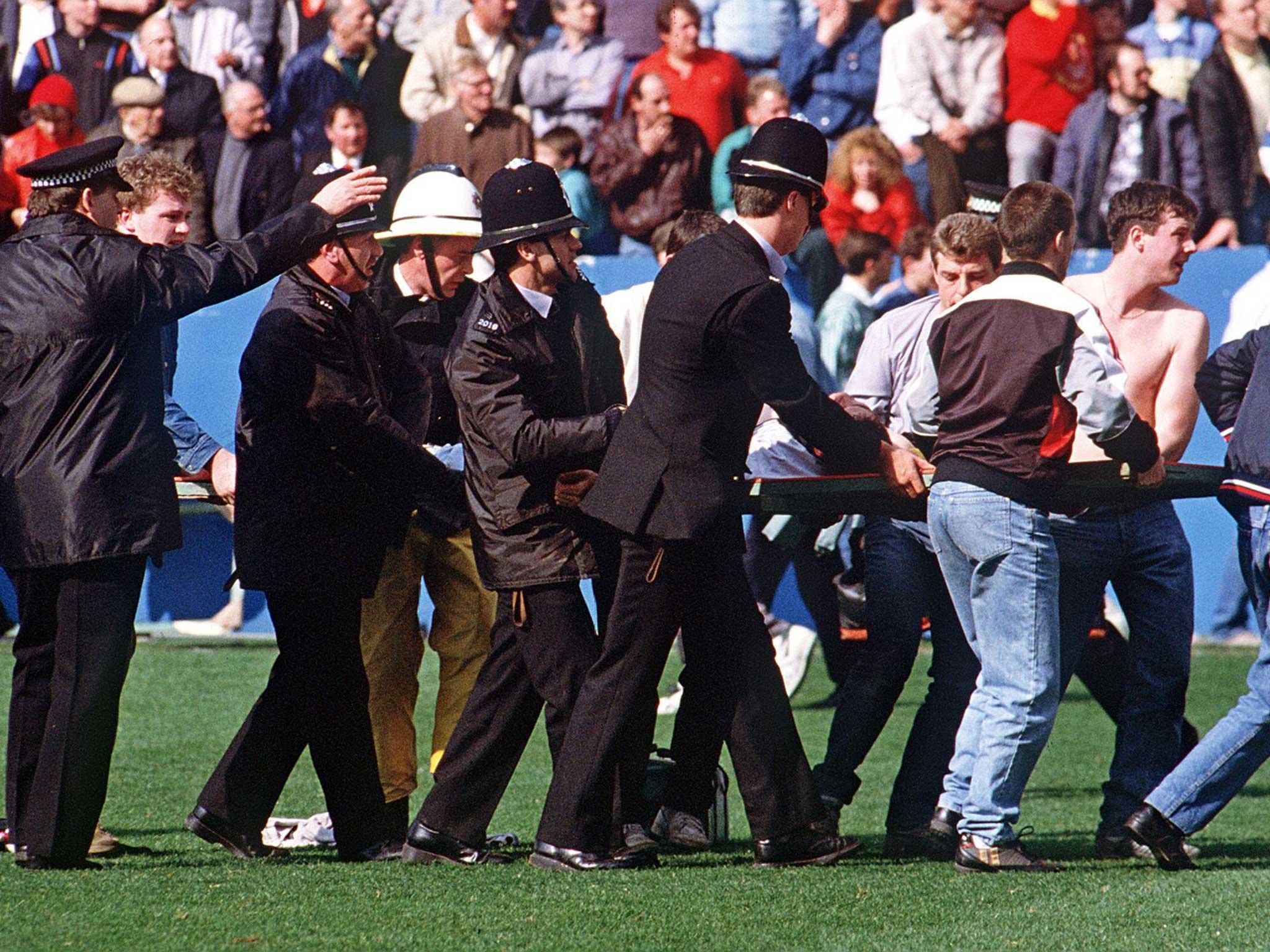 Policemen rescue soccer fans at Hillsborough stadium after support railings collapsed during a match between Liverpool and Nottingham forest (Getty Images)