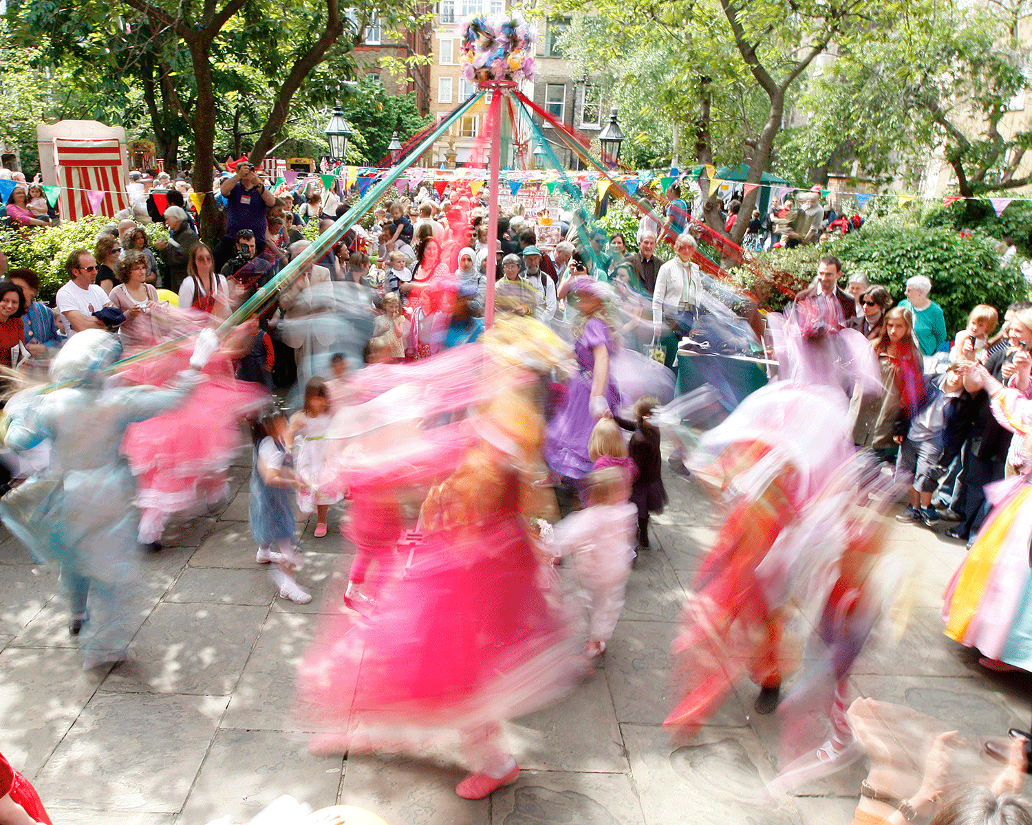 Children dressed as May Queens dance around a maypole in Covent Garden, London