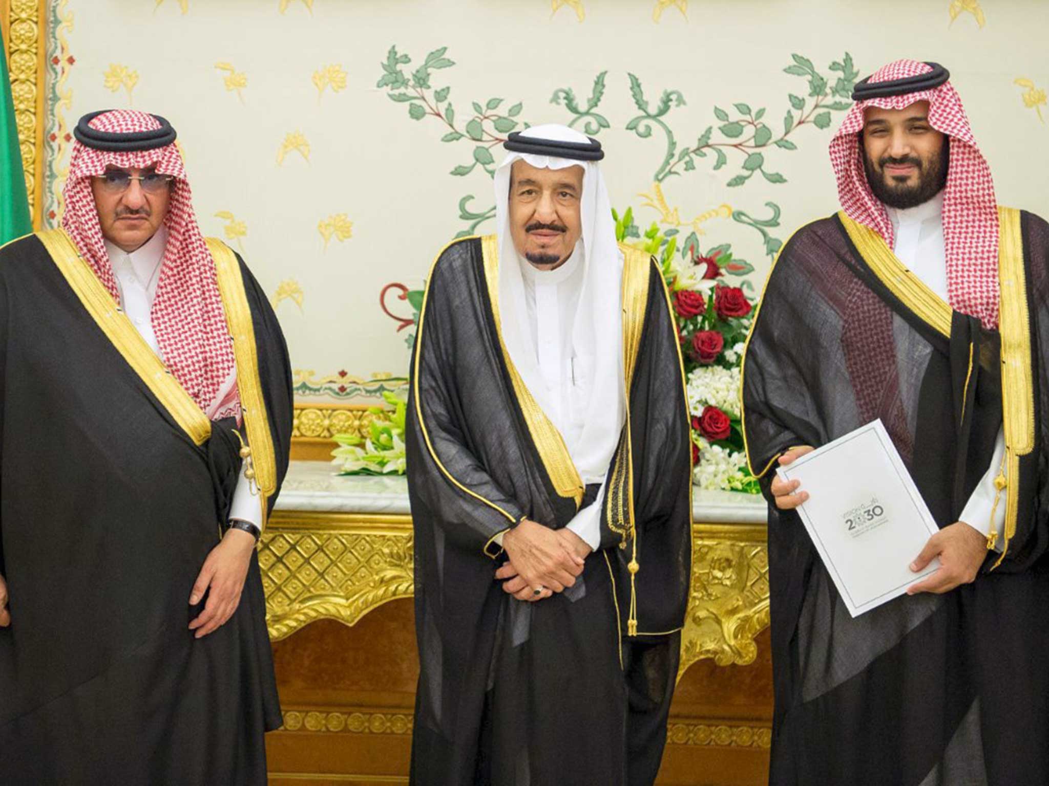 (L-R) Saudi Crown Prince Mohammed bin Nayef, Saudi King Salman, and Saudi Arabia's Deputy Crown Prince Mohammed bin Salman stand together after Saudi Arabia's cabinet agrees to implement a broad reform plan known as Vision 2030 in Riyadh