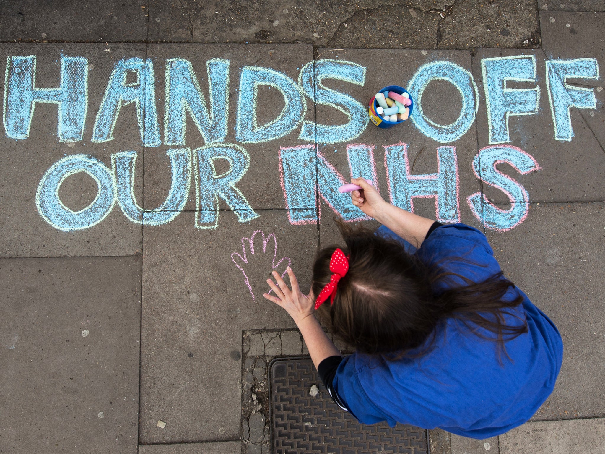 A junior doctor draws in chalk on the pavement outside King's College hospital in London