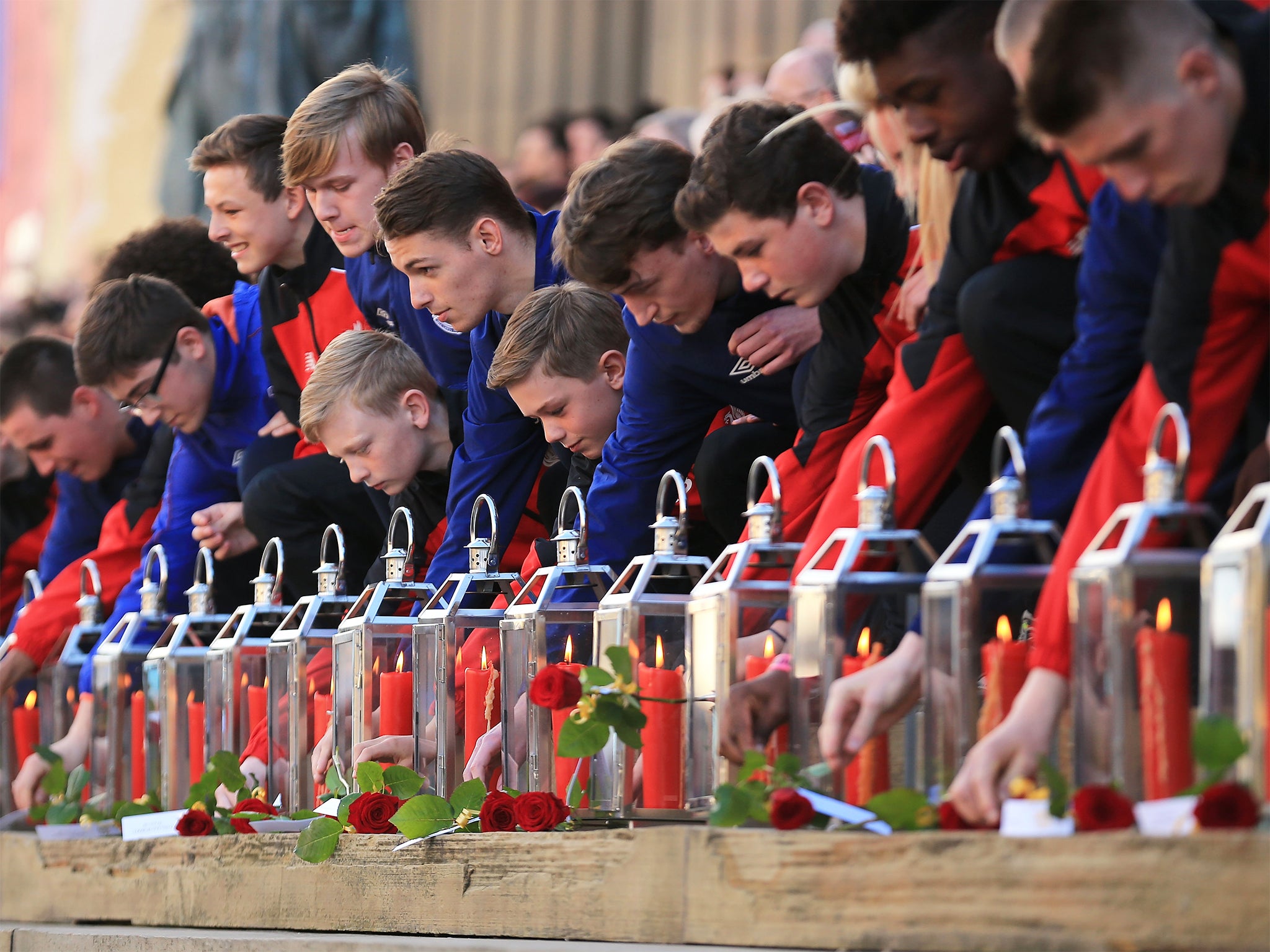 Representatives of Liverpool and Everton football clubs lay red roses beside 96 candles in memory of the victims