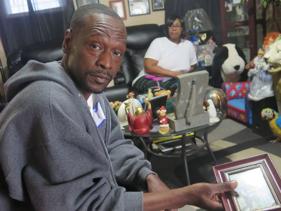 Andre Price holds a photo of his daughter in his Milwaukee home