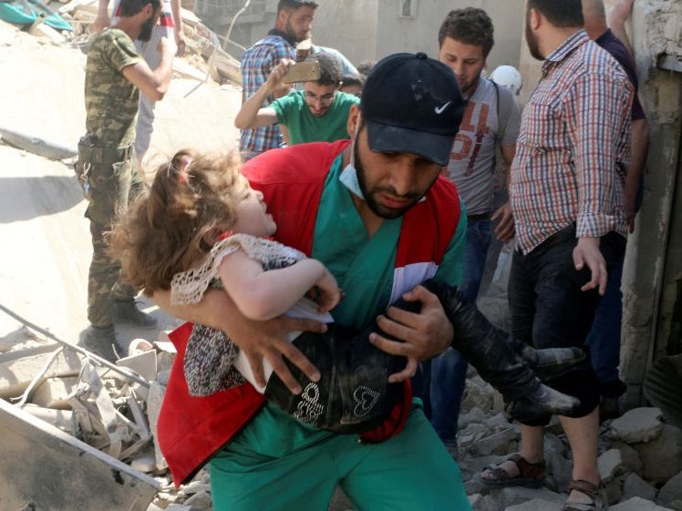 A man leads a woman in tears and child out of the scene after airstrikes hit Aleppo