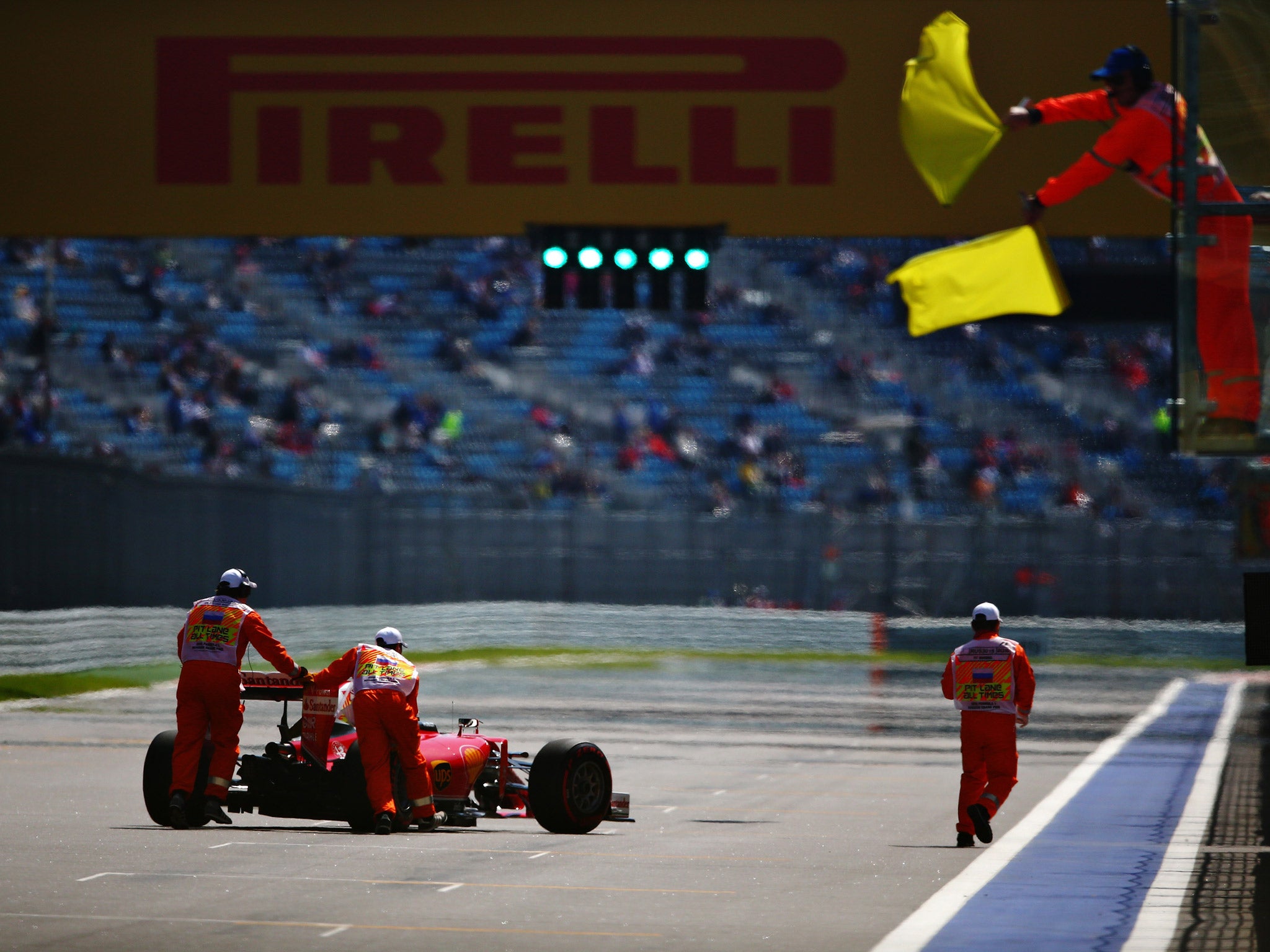 Sebastian Vettel's Ferrari is wheeled away after stopping on the start/finish straight