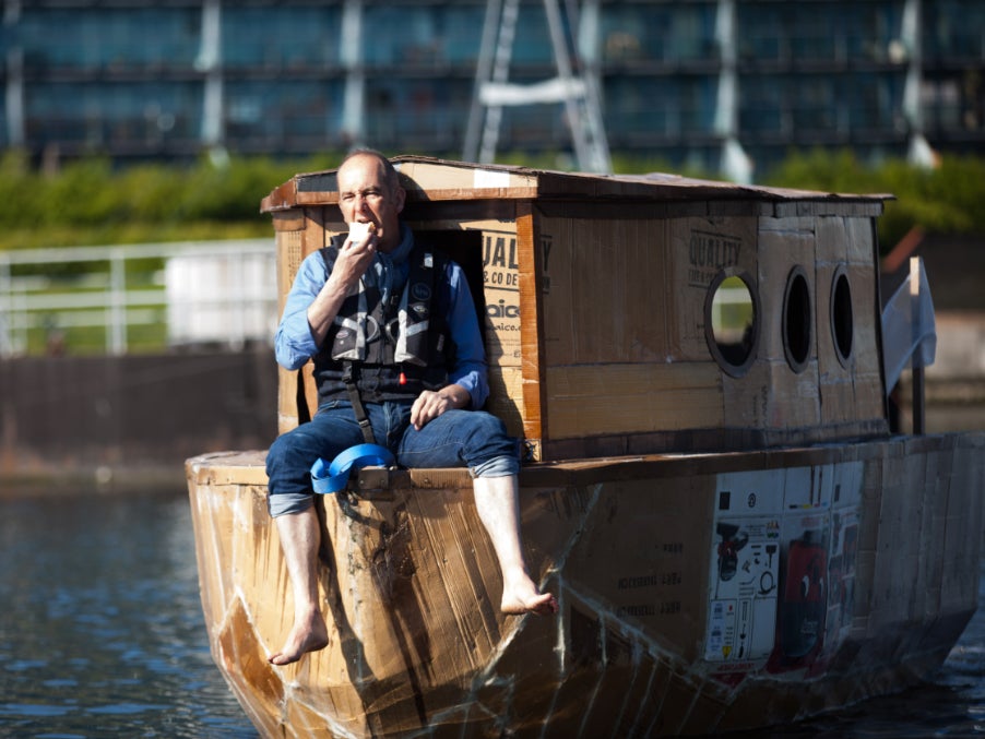 Kevin McCloud sailing in the cardboard houseboat on the River Thames