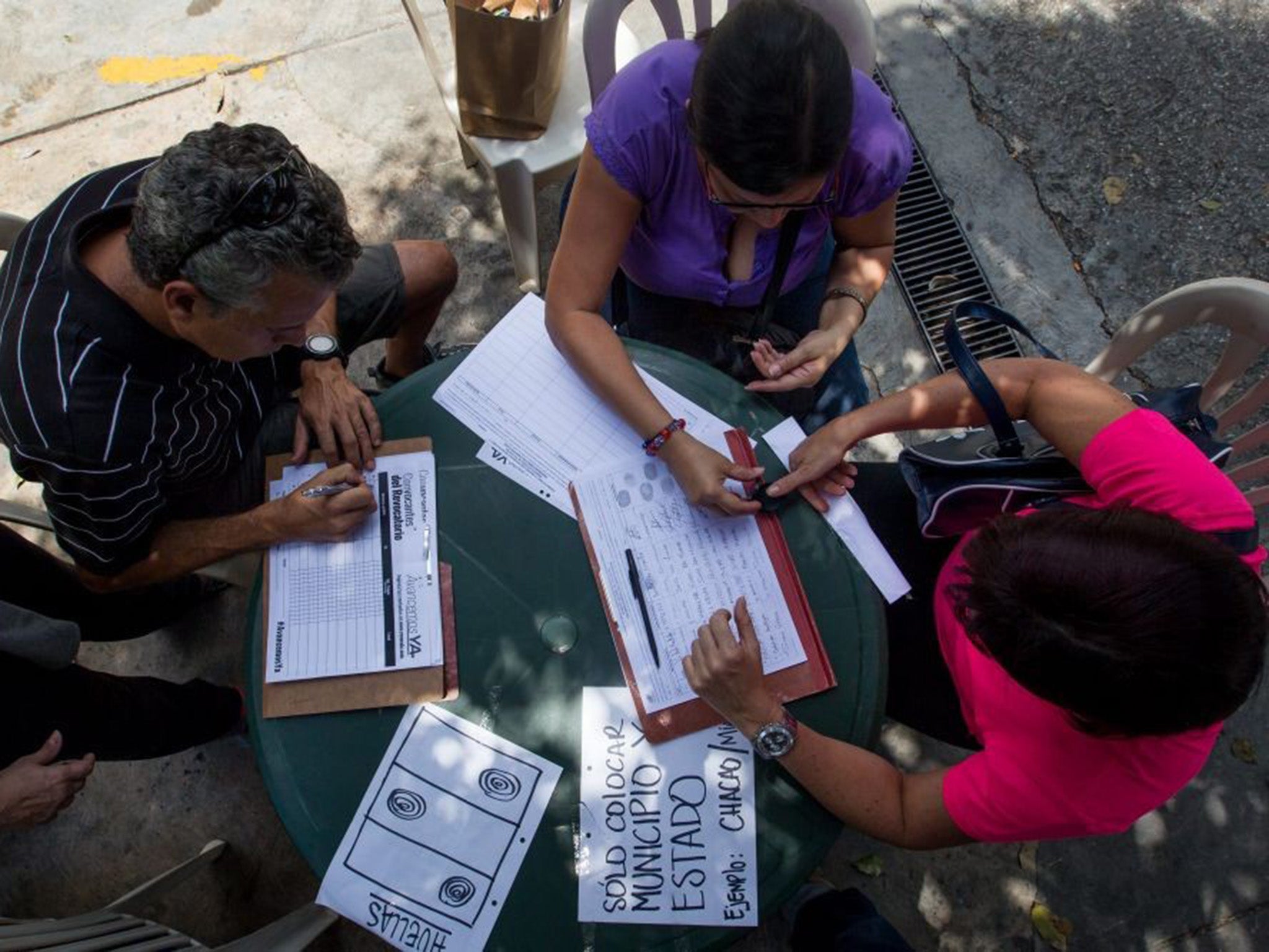 People signing petition to impeach President Nicolas Maduro. Opposition leaders say nearly two million have signed the petition so far