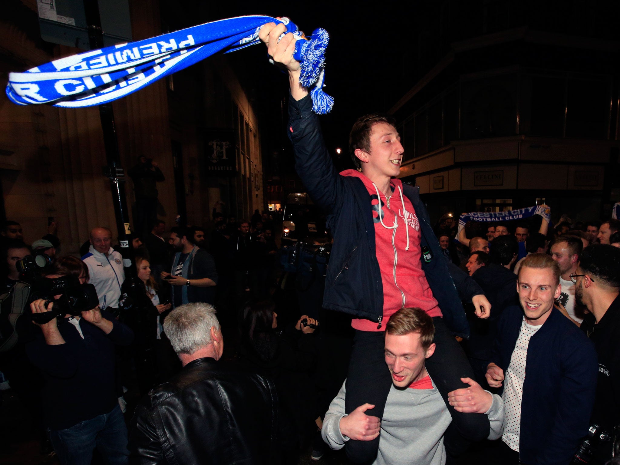 Leicester City fans celebrate in the streets of the city after seeing their side crowned Barclays Premier League champions