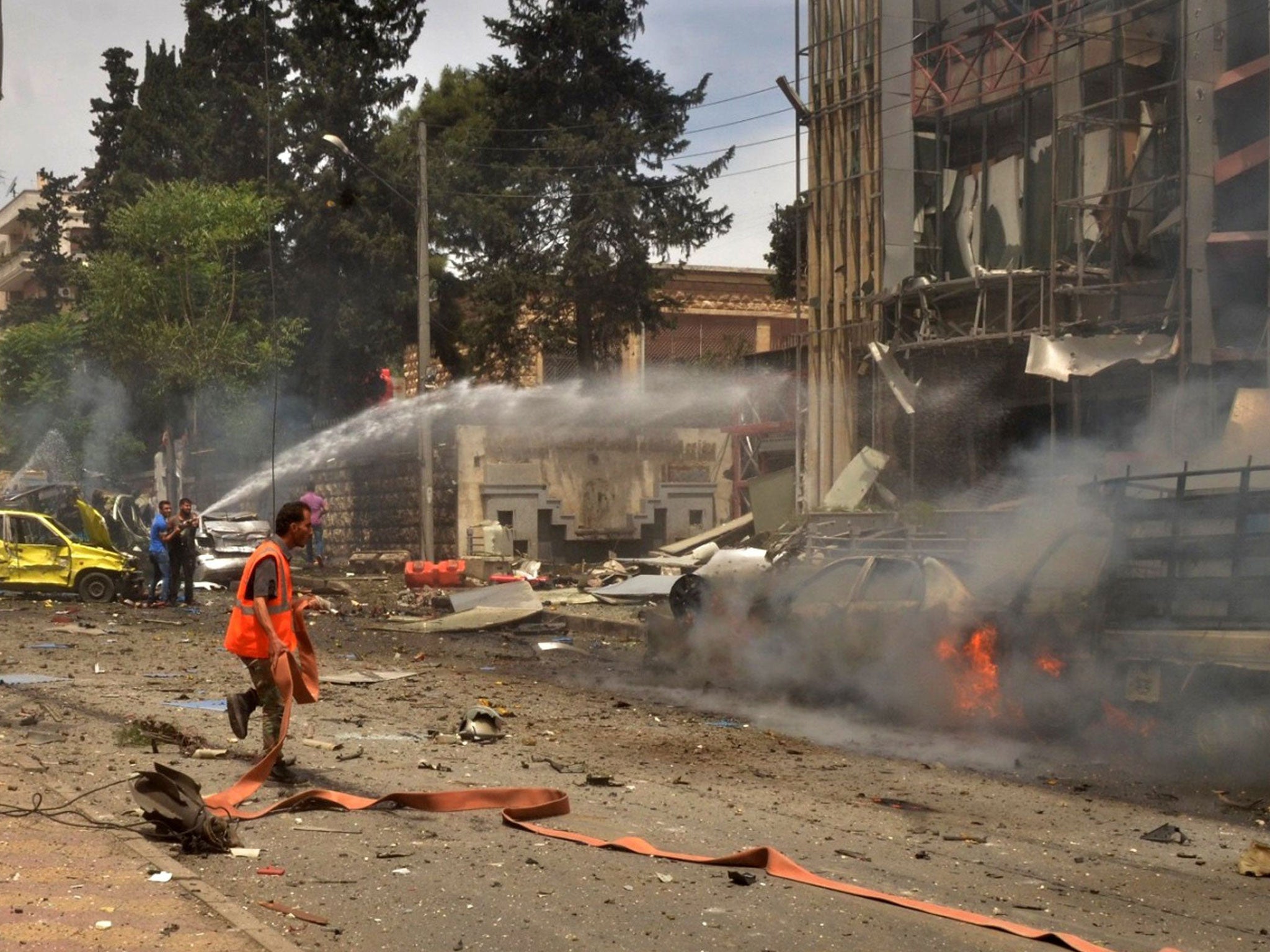 Syrian emergency personnel extinguish fires in Al-Dabbit hospital after rockets reportedly fired by rebels hit the government-controlled neighbourhood of Muhafaza in the northern city of Aleppo on May 3, 2016.