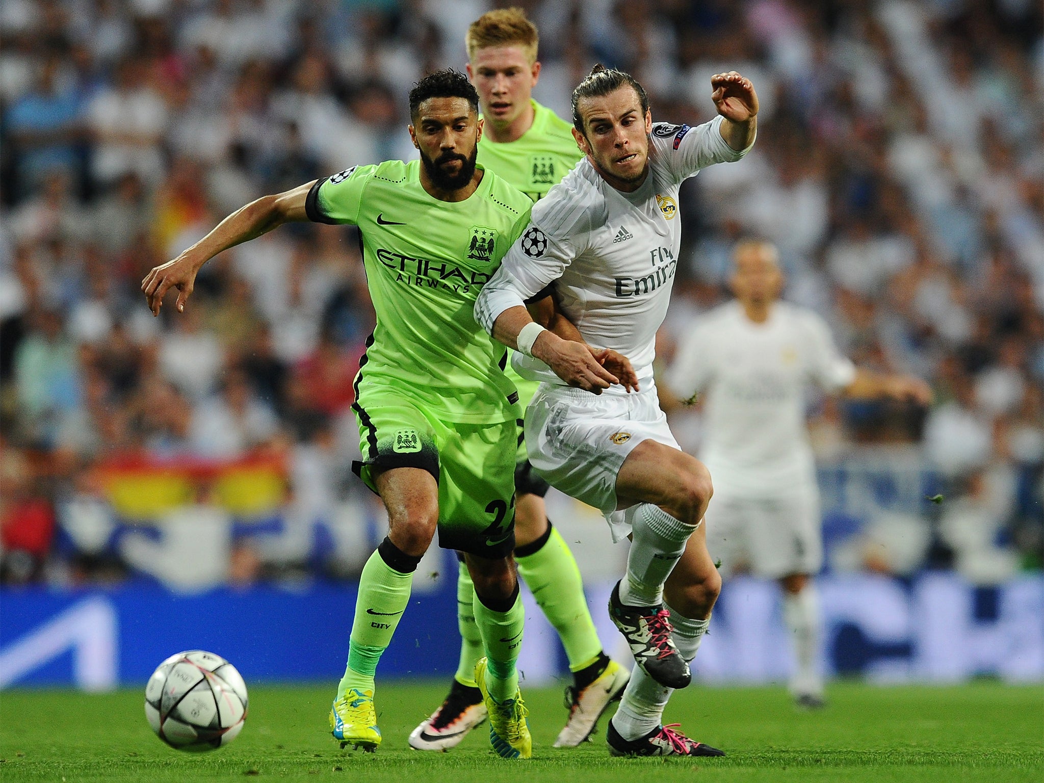 Gareth Bale competes for the ball with Gael Clichy