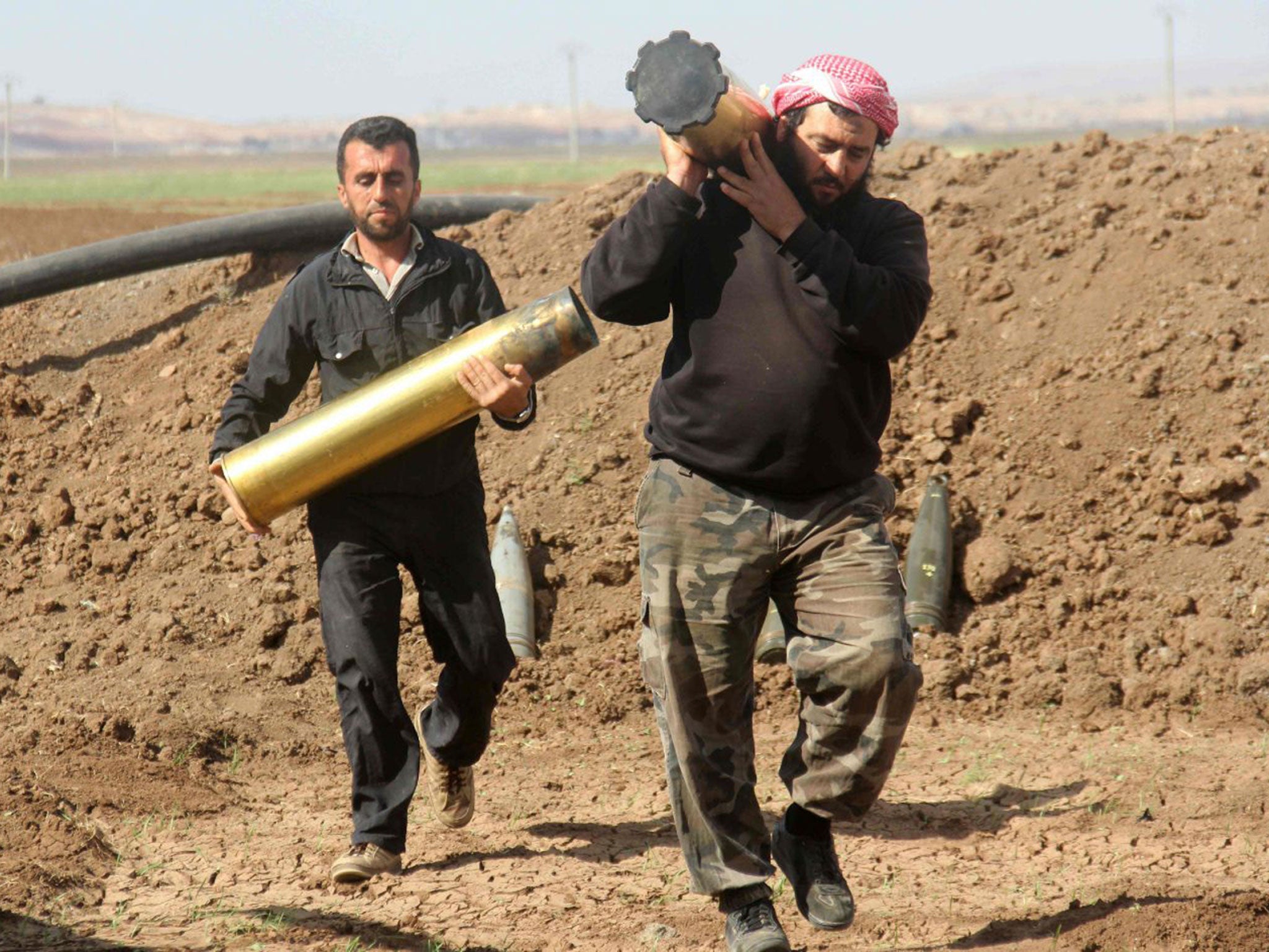 Rebel fighters from the Jaish al-Fatah (Army of Conquest) prepare to fire home-made rockets during clashes with Syrian pro-government forces in Aleppo's southern countryside