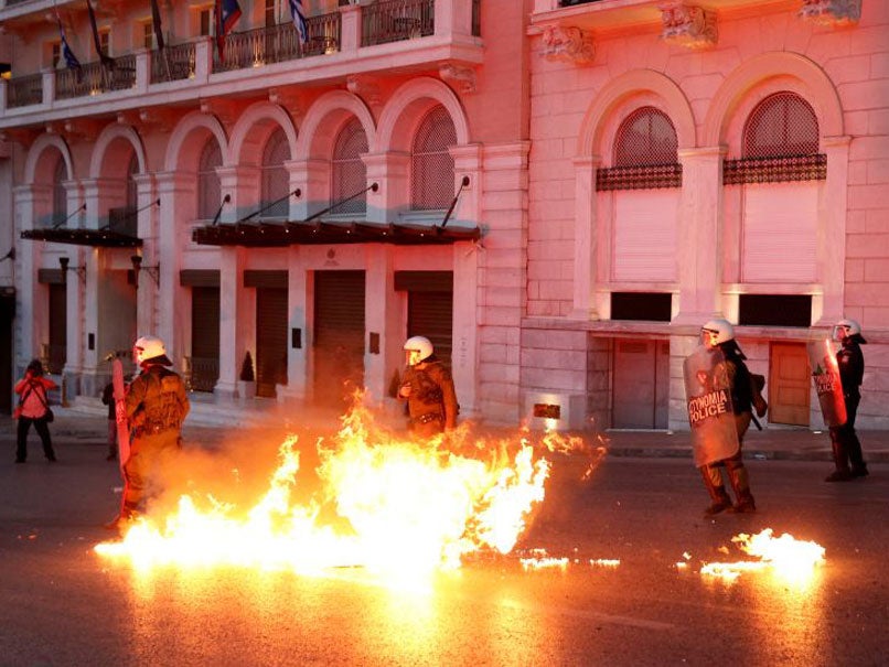 Greek riot police officers dodge petrol bomb thrown by protesters during minor clashes following a protest outside parliament in central Athens where lawmakers were discussing controversial tax and pension reforms May 8, 2016