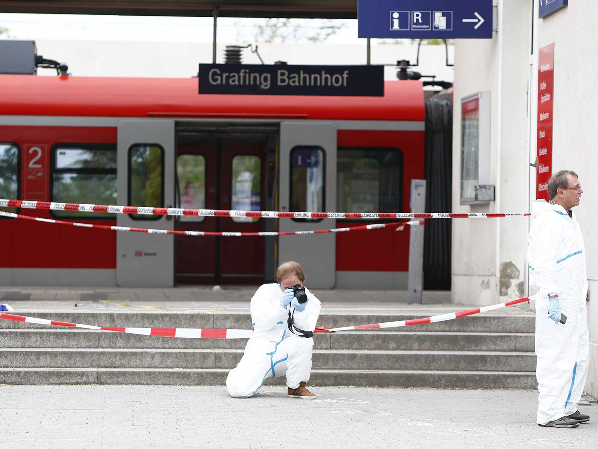 A police officer takes pictures at the train station after an attack in Munich. One person has been killed and several injured after suspected Islamist stabbed passers-by at a railway station in Grafing