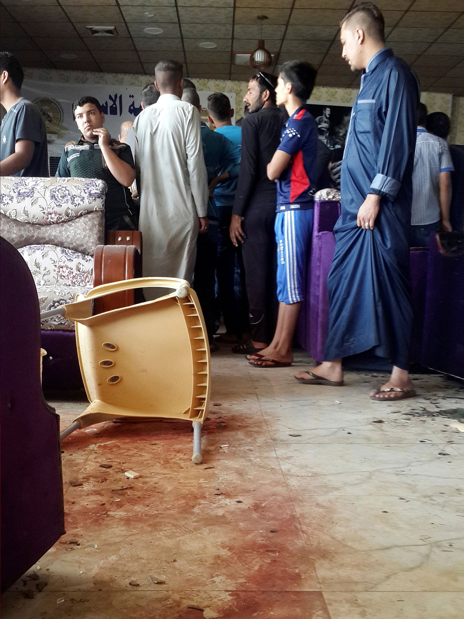 Blood stains are seen in the cafe as people gather on the morning after the attack.