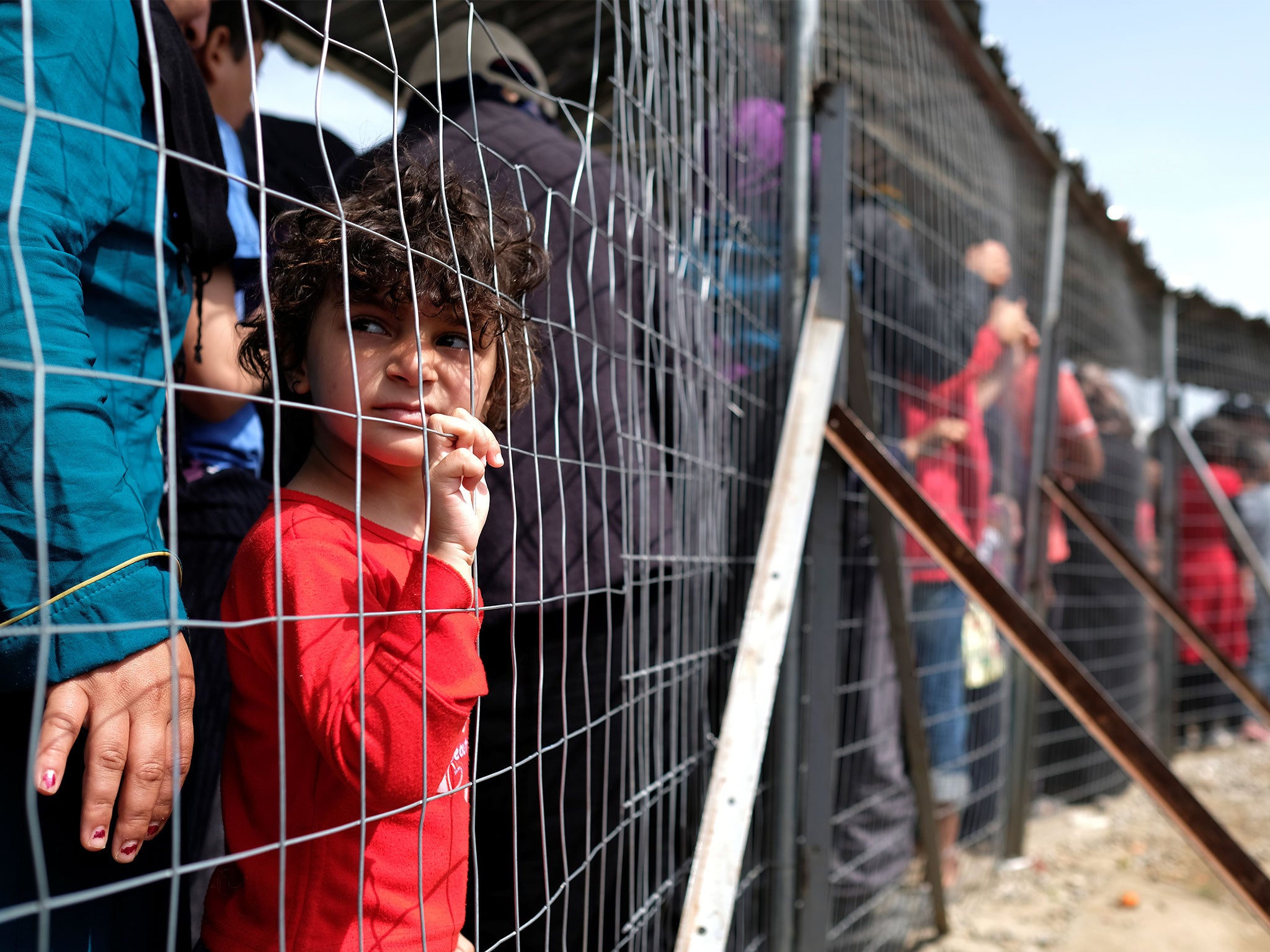 A girl queues for free food at a makeshift camp for migrants and refugees at the Greek-Macedonian border near the village of Idomeni, Greece