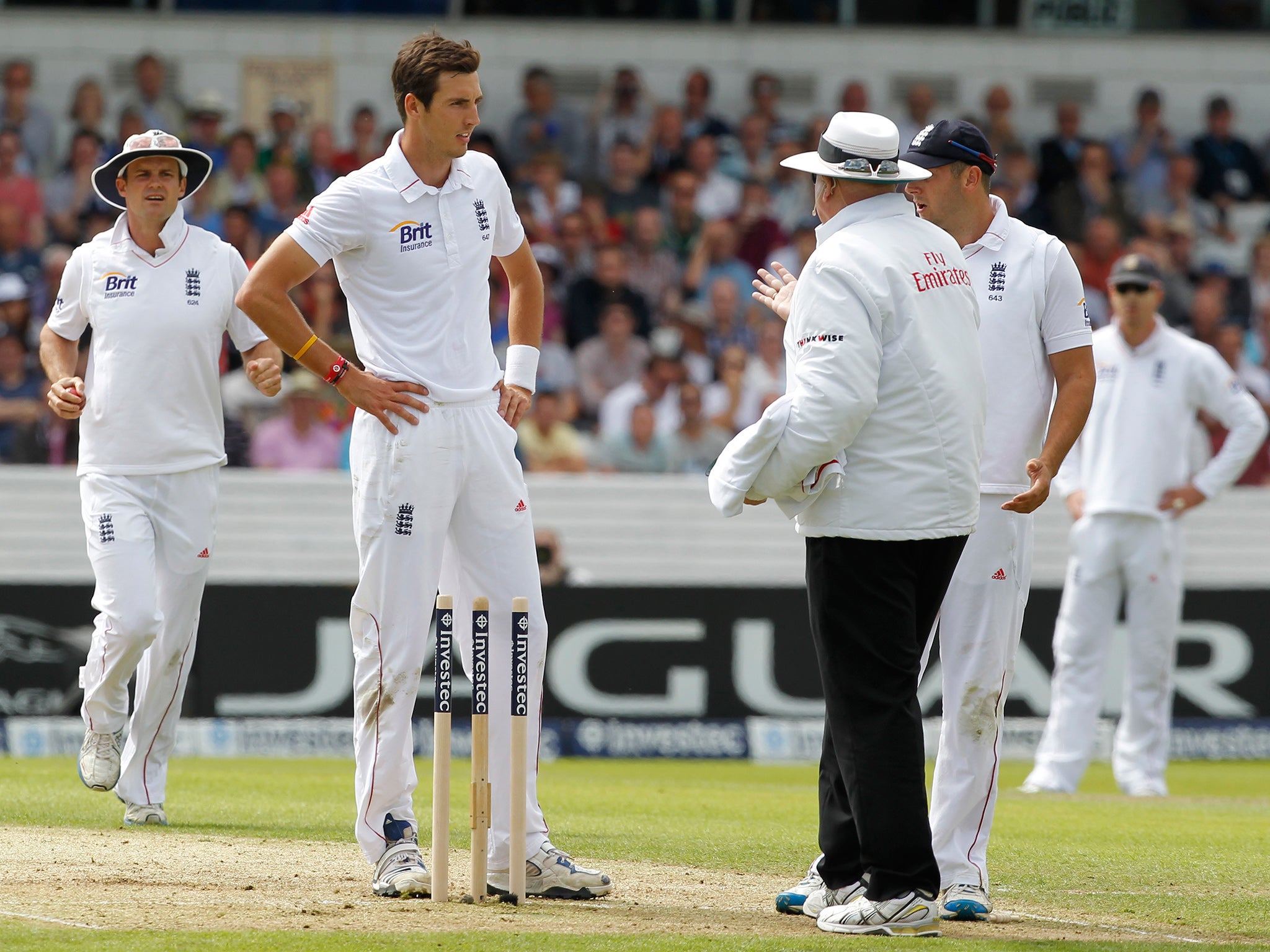 Steven Finn speaks to the umpire after knocking the bails off whilst bowling