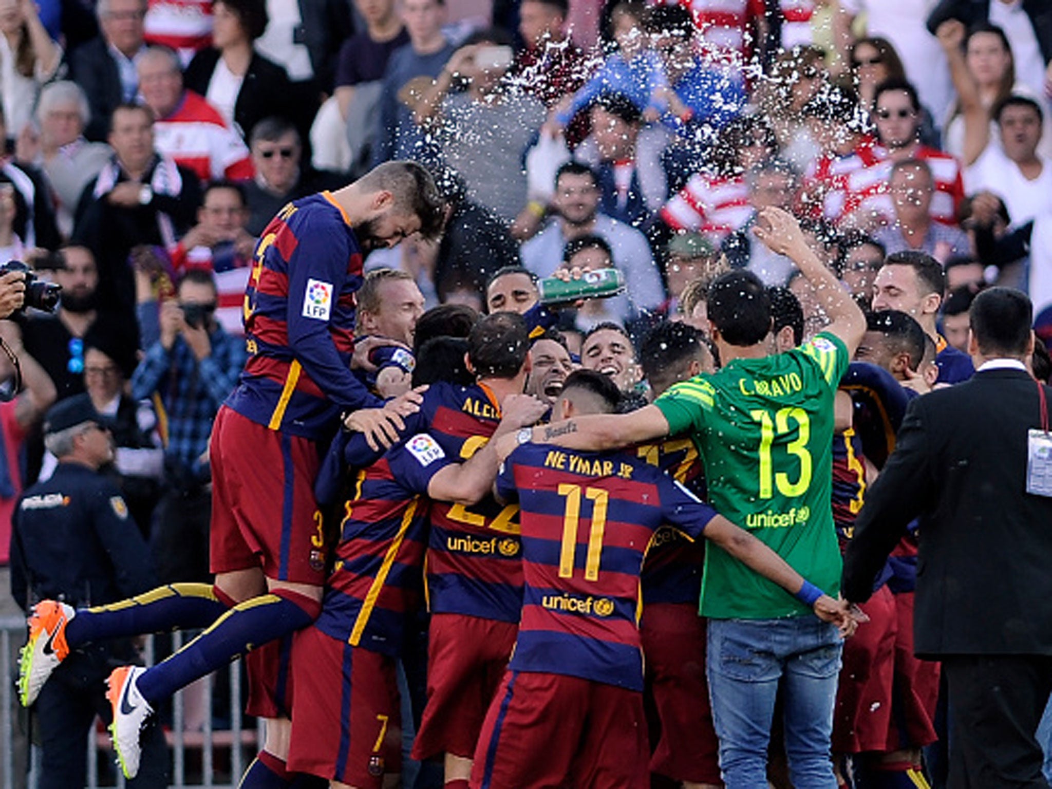 Barcelona players celebrate retaining their La Liga title after a 3-0 victory at Granada