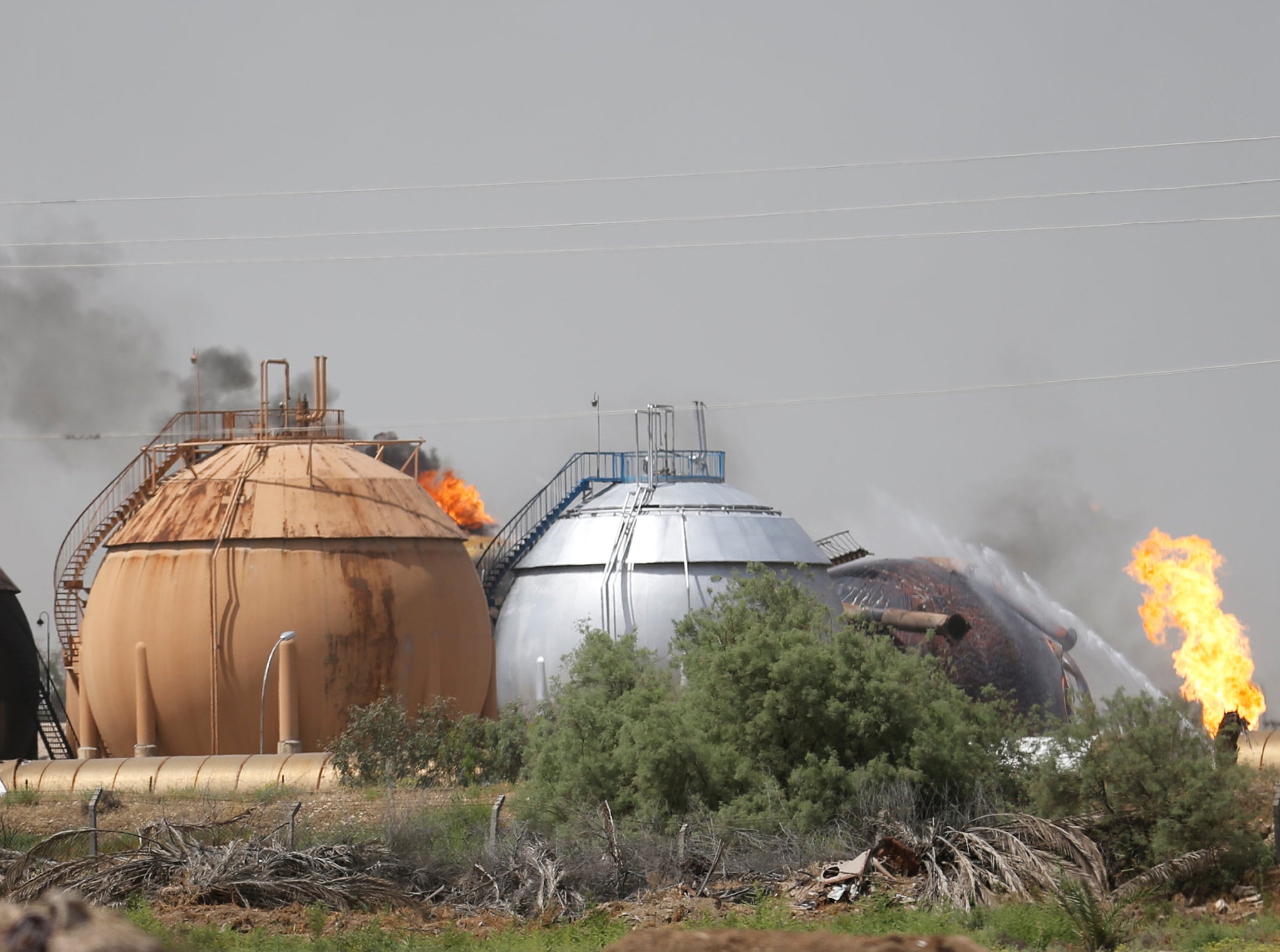 Smoke rises from gas storage tanks after a bomb attack against a state-run cooking gas factory in Taji at Baghdad's northern outskirts