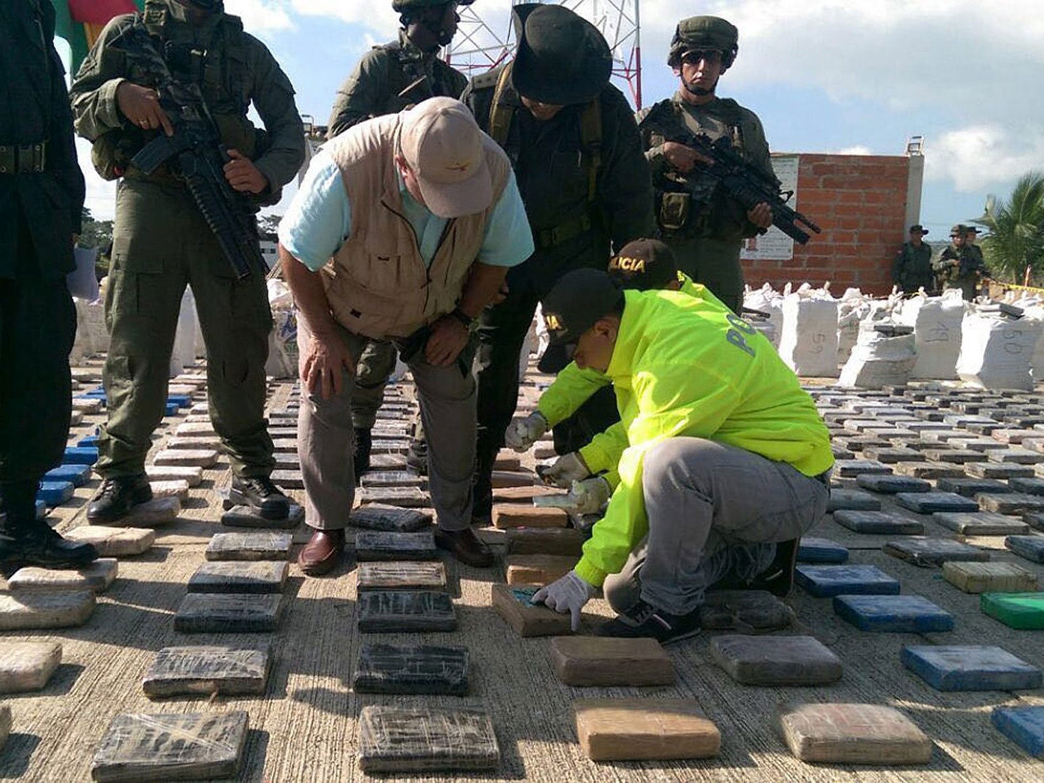 Colombian Minister of Defense Luis Carlos Villegas (C) looking at confiscated packages of cocaine